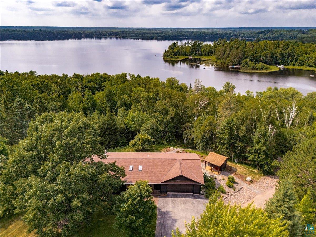 Image 0: Expansive property featuring a lakefront setting, mature trees, a detached outbuilding, and a private driveway, Aerial View