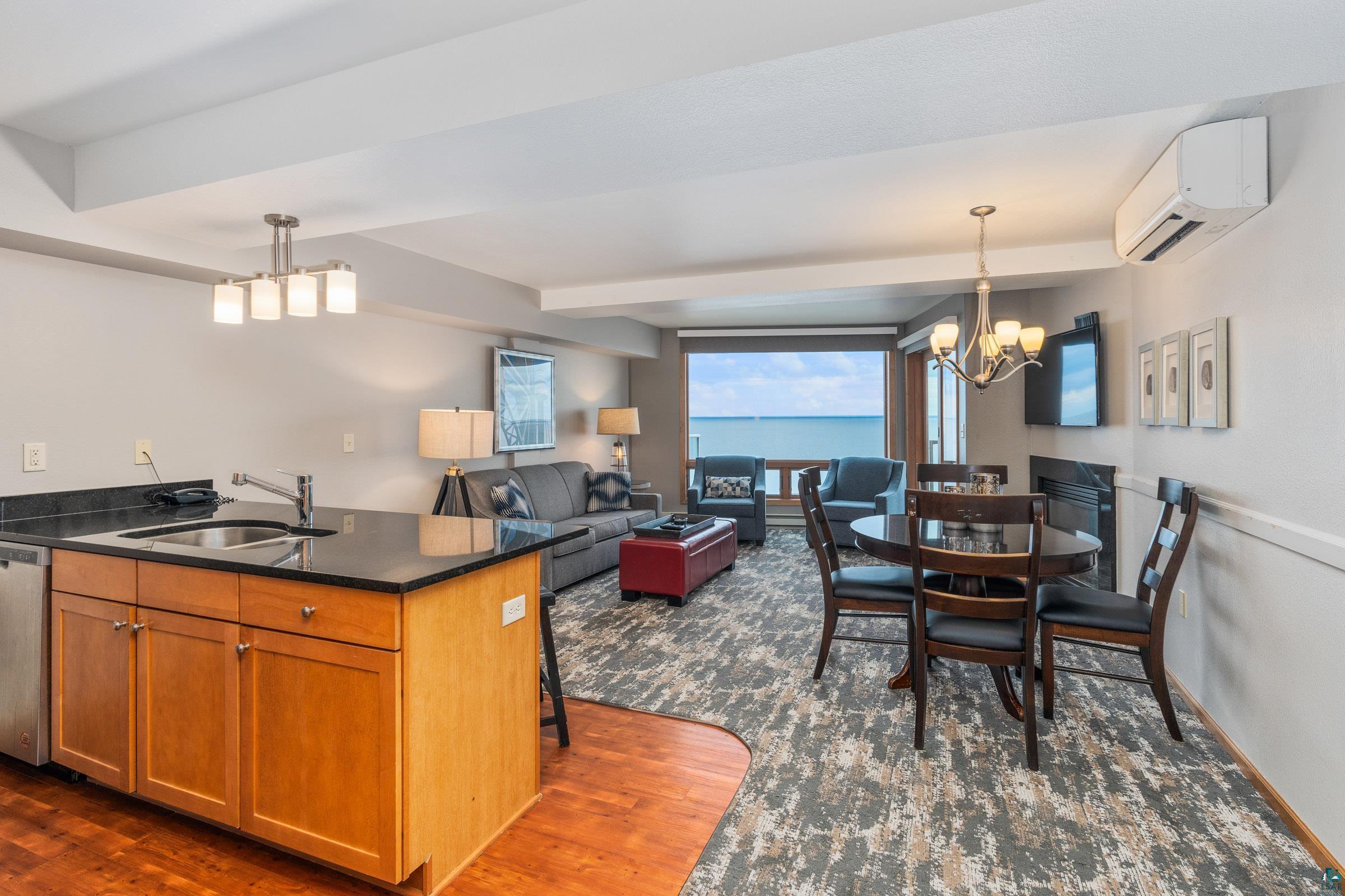 Image 2: Kitchen featuring hardwood / wood-style floors, a water view, decorative light fixtures, an inviting chandelier, and sink, Kitchen