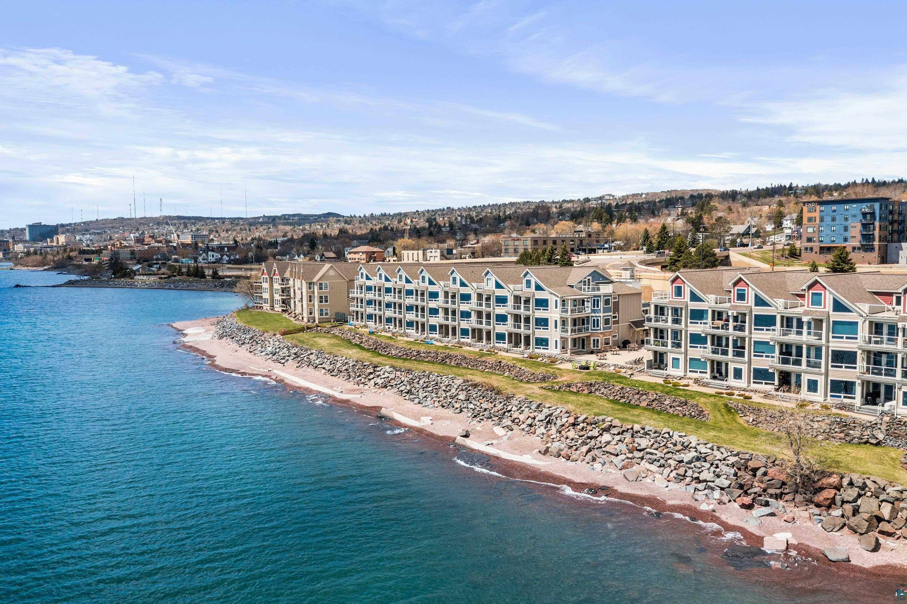 Image 1: Waterfront multi-story buildings featuring balconies and extensive window arrays, Aerial View