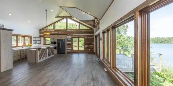 Image 3: Living space opens up to kitchen and dining space with expansive views of Lake Superior., Living Room