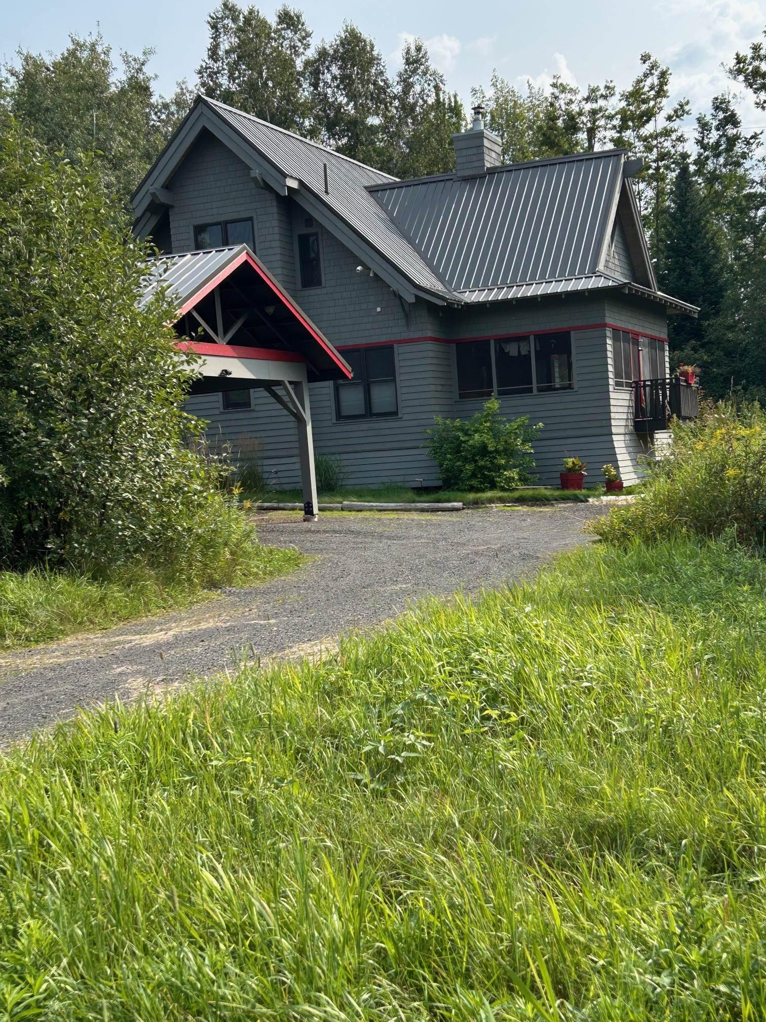 Image 0: View of front of house with a metal roof and a chimney, Front Of Structure