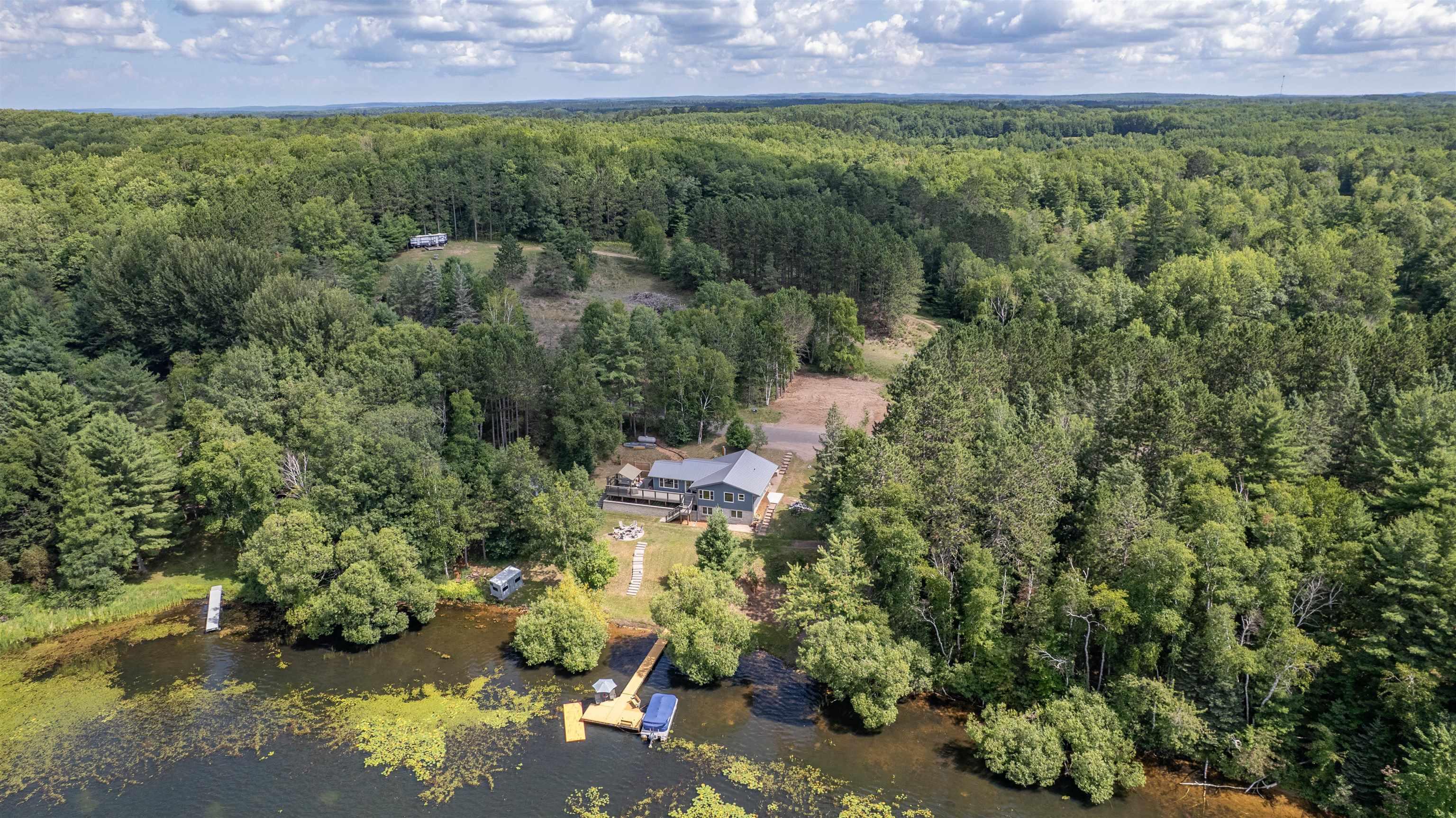 Image 2: Aerial view of property's location with a nearby body of water and a forest, Aerial View