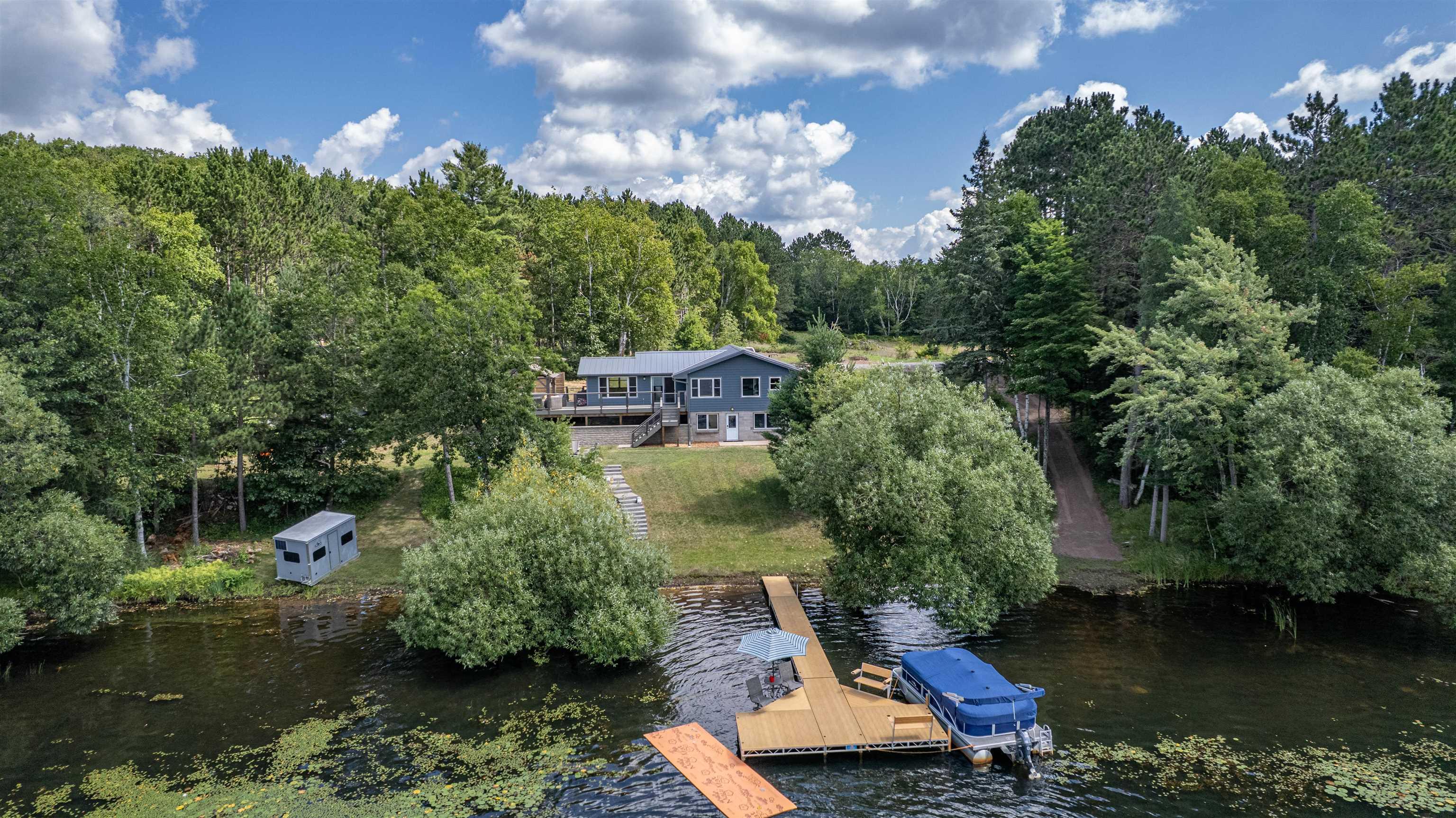 Image 3: View from above of property featuring a nearby body of water and a heavily wooded area, Aerial View