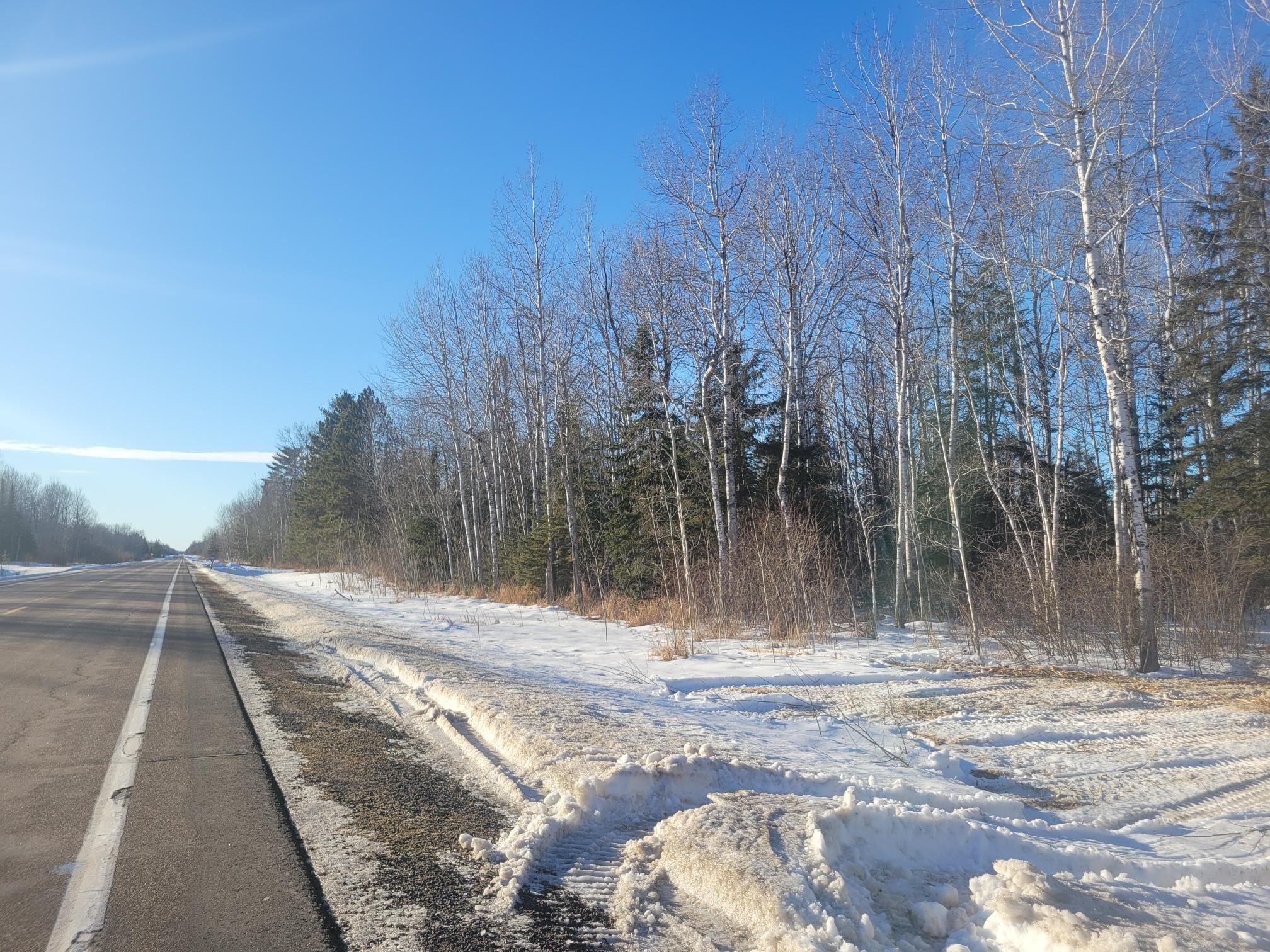 Image 1: View of asphalt road featuring a wooded view, Community