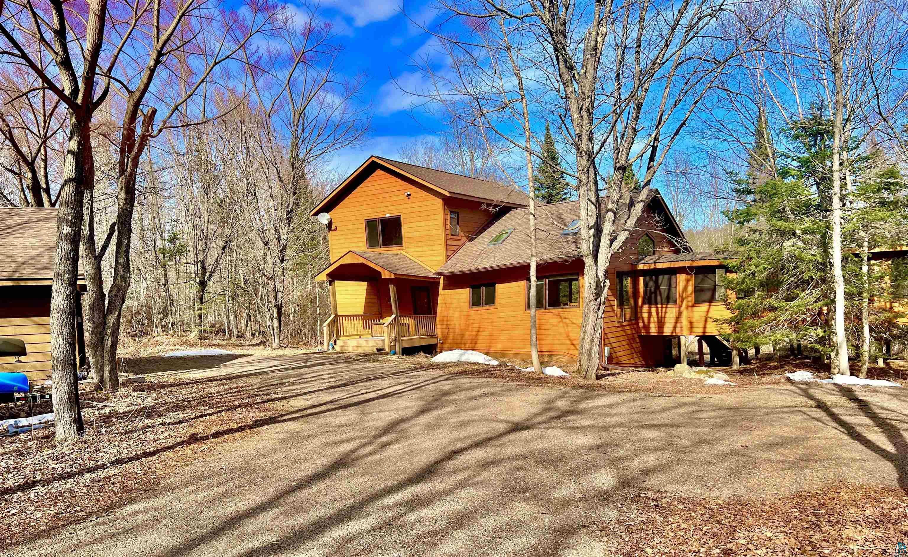 Image 1: Two-story wood-sided residence featuring an expansive gravel driveway, Maple Trees