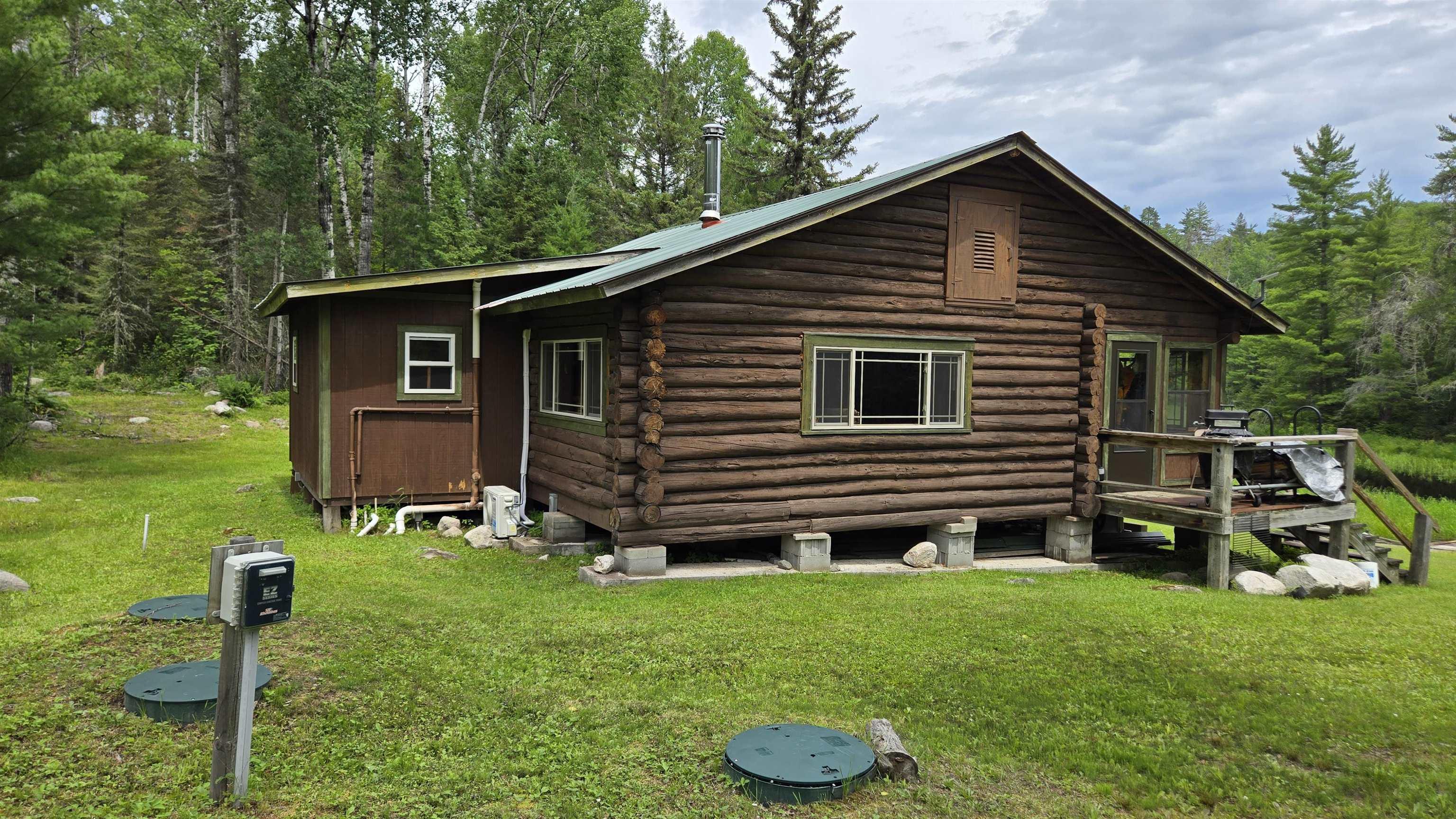 Image 3: Back of house featuring log exterior, a yard, and a wooded view, Back Of Structure