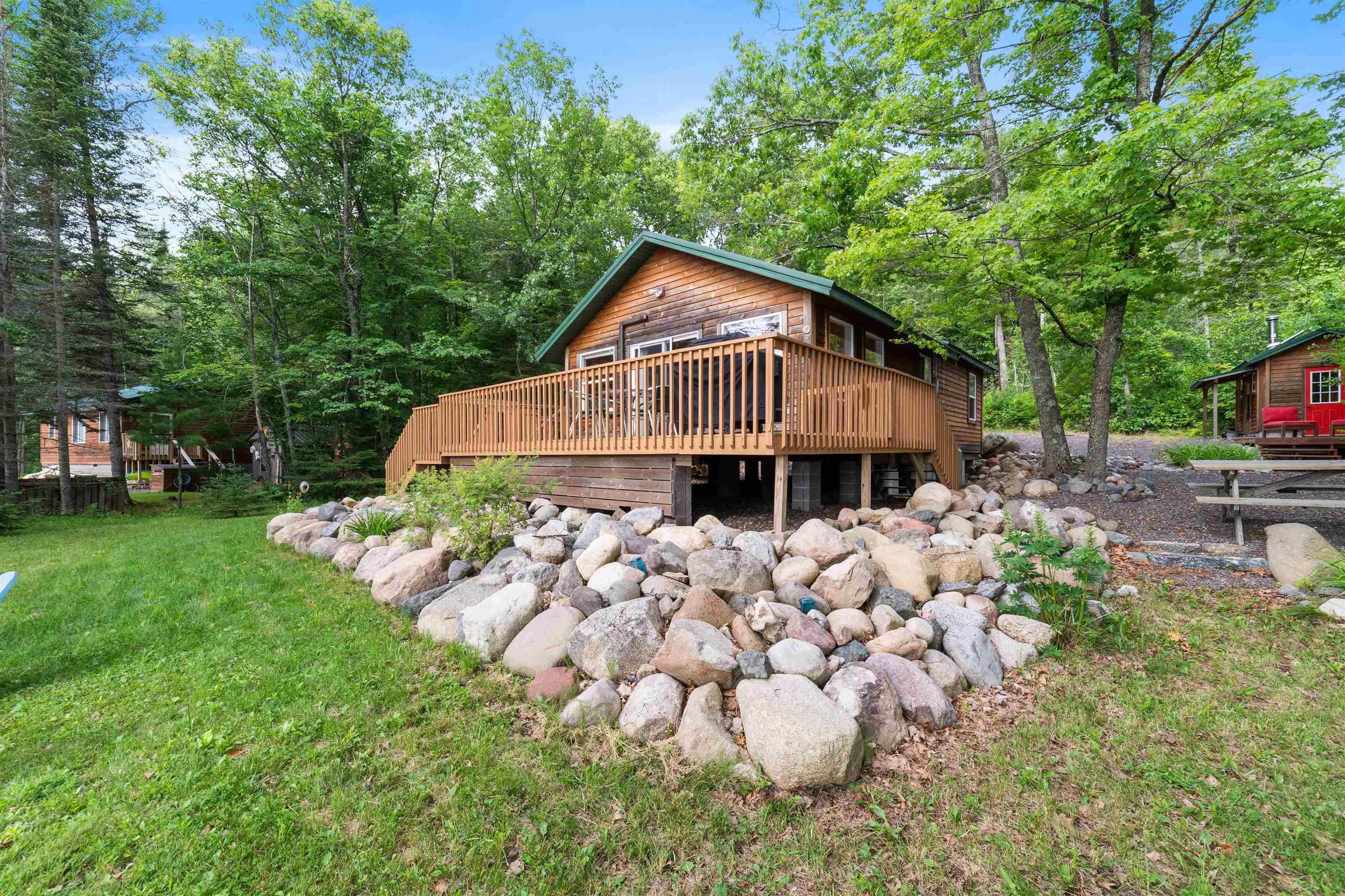 Image 2: Back of house featuring a deck and a lawn, Back Of Structure
