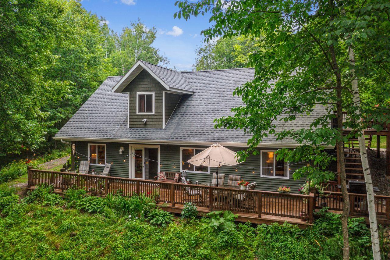Image 0: Rear view of property with a wooden deck, a shingled roof, and outdoor dining space, Back Of Structure