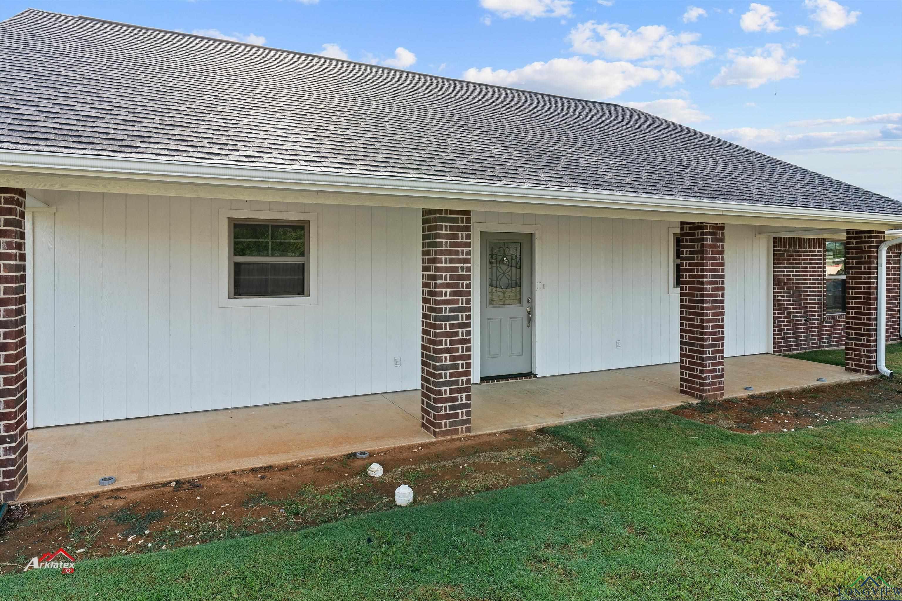 Image 2: Exterior space featuring brick siding, roof with shingles, and a lawn, Entry