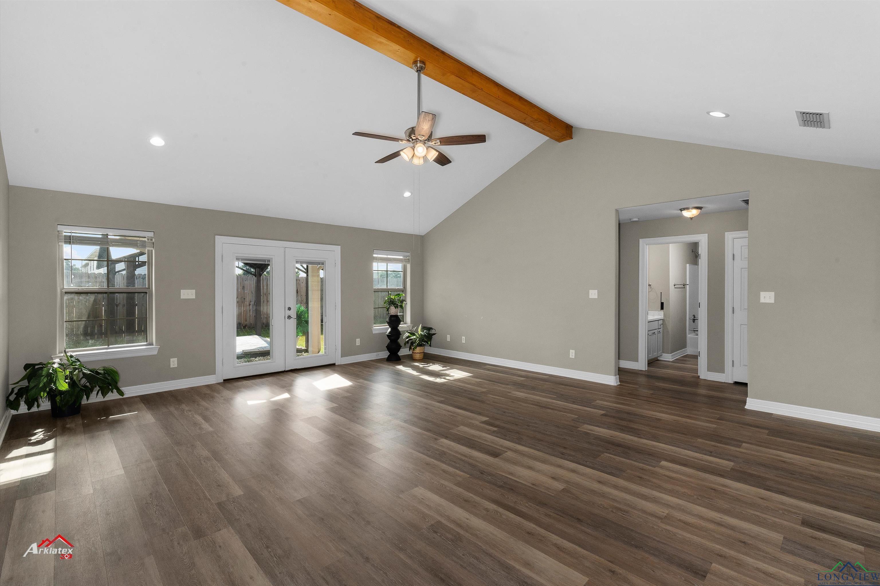 Image 3: Unfurnished living room featuring ceiling fan, visible vents, french doors, beam ceiling, and dark wood-style flooring, Living Room