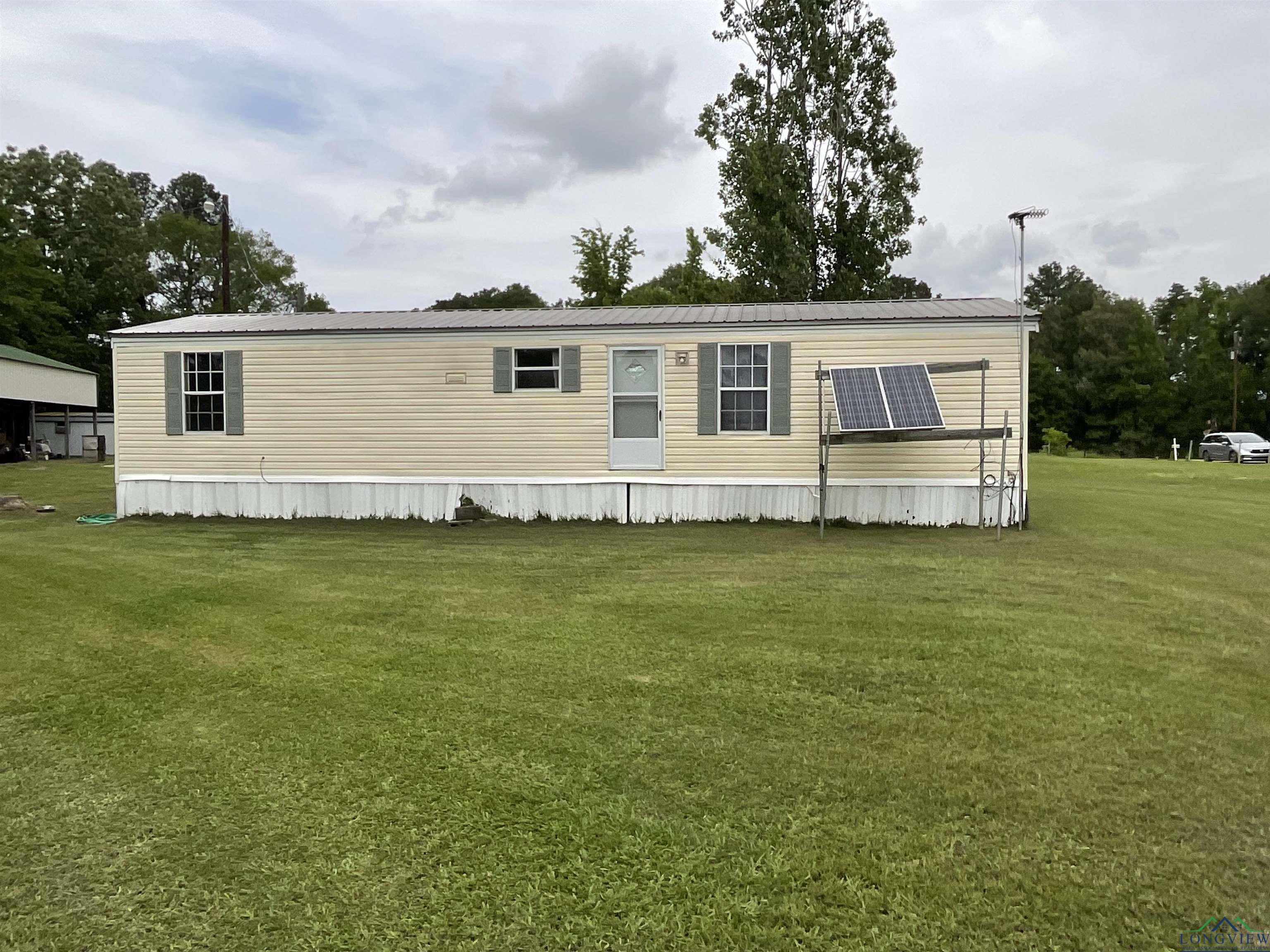 Image 2: View of front of property with metal roof and a front yard, Front Of Structure
