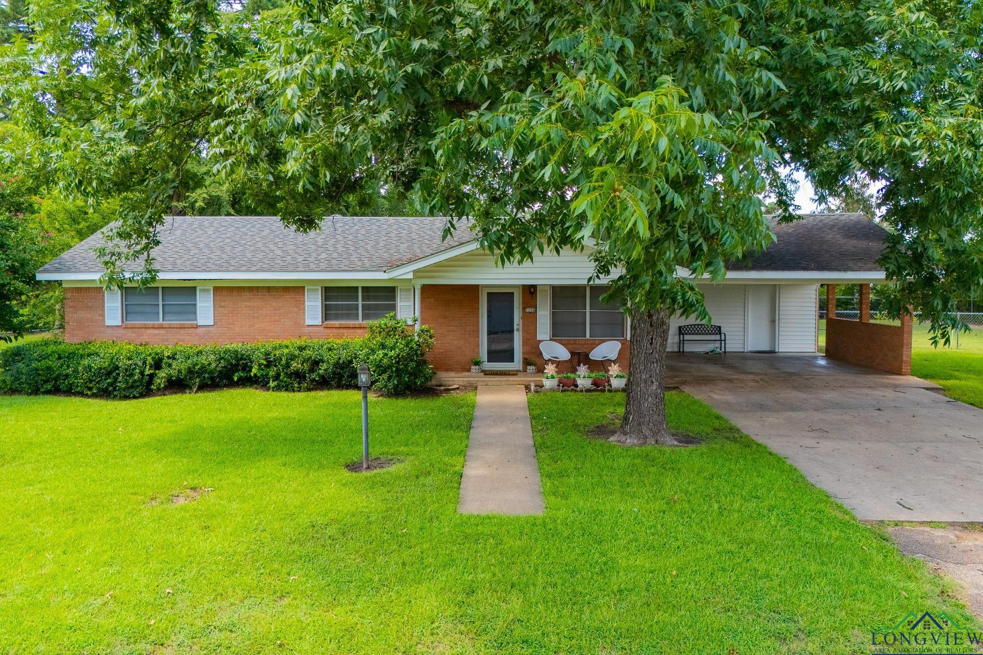 Image 0: Ranch-style home with concrete driveway, an attached carport, a front lawn, and brick siding, Front Of Structure