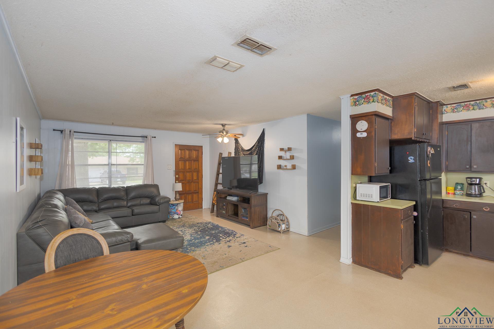 Image 3: Living area with a textured ceiling and a ceiling fan, Living Room