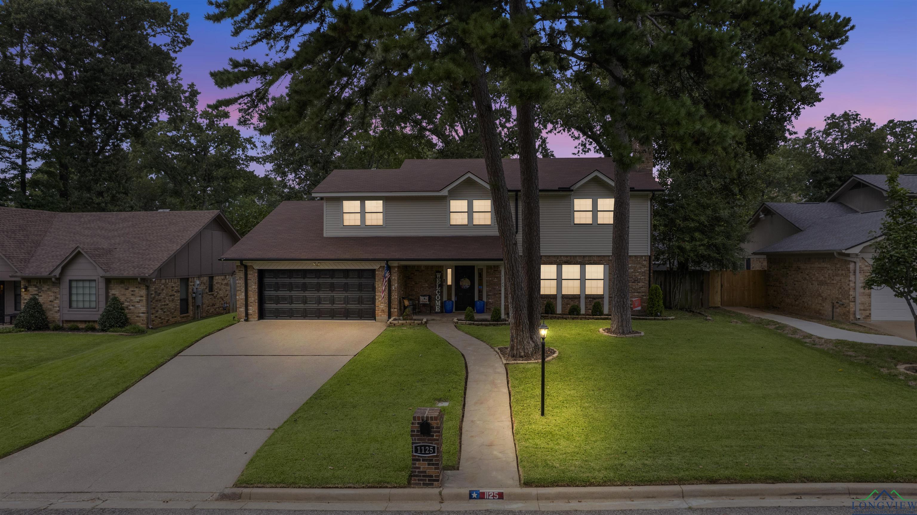 Image 2: Traditional-style house featuring a porch, driveway, brick siding, and a garage, Front Of Structure