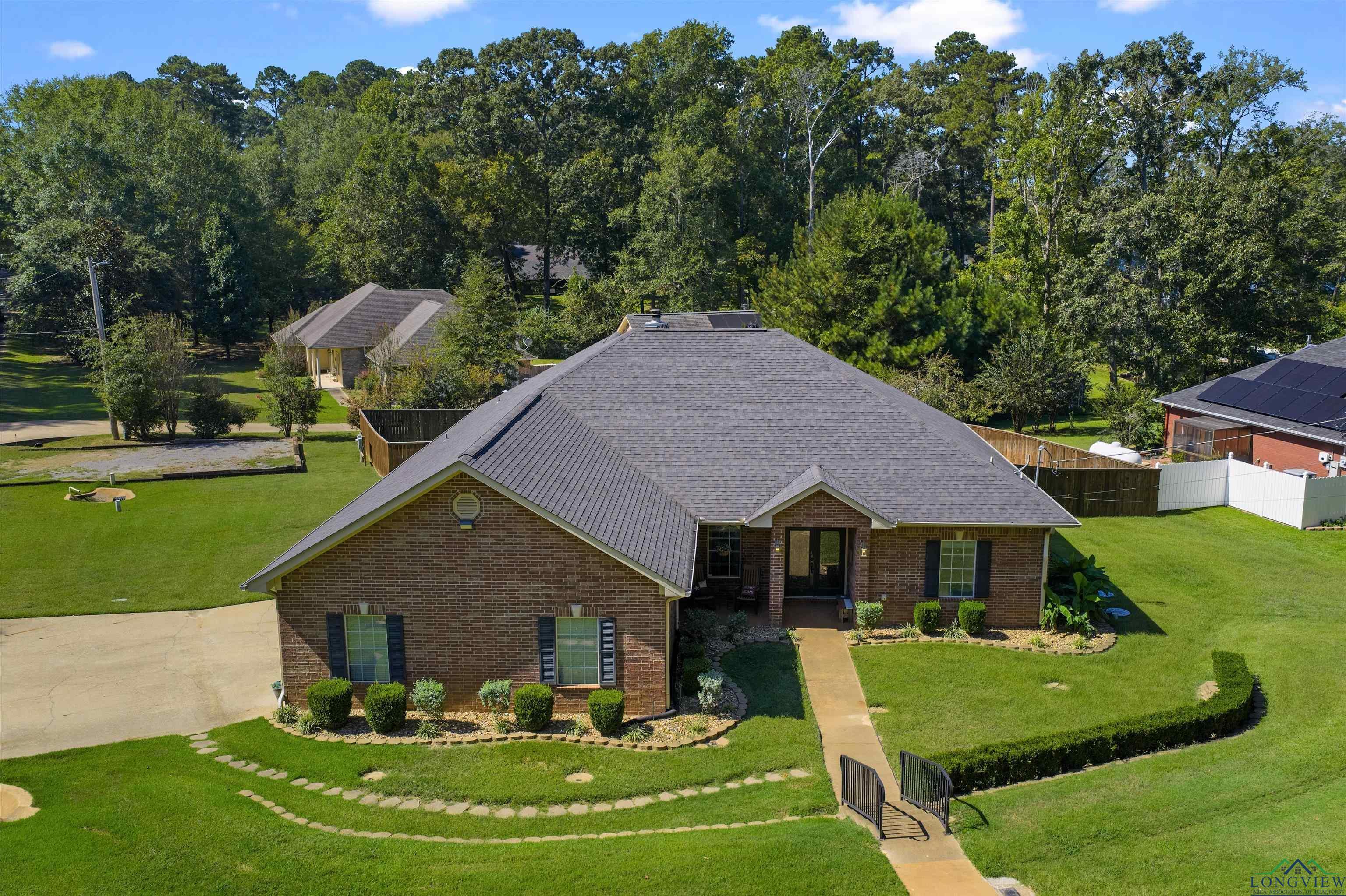 Image 1: View of front facade with brick siding, a front yard, and a shingled roof, Front Of Structure