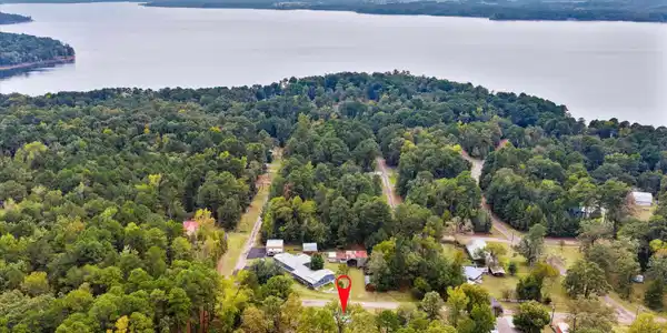 Image 3: Drone / aerial view of a nearby body of water and a heavily wooded area, Aerial View