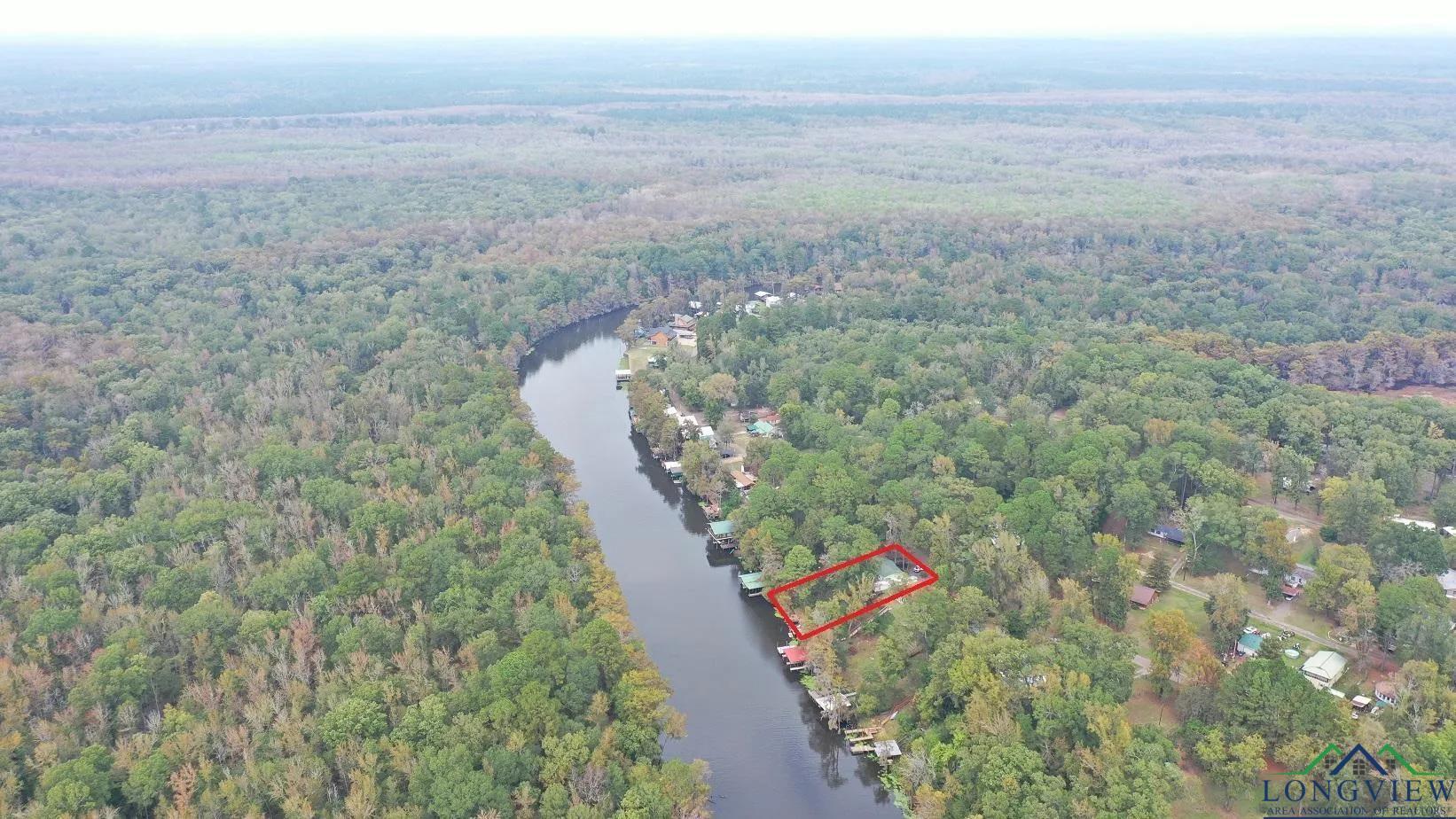 Image 1: View of property location with a large body of water and property parcel outlined, Aerial View