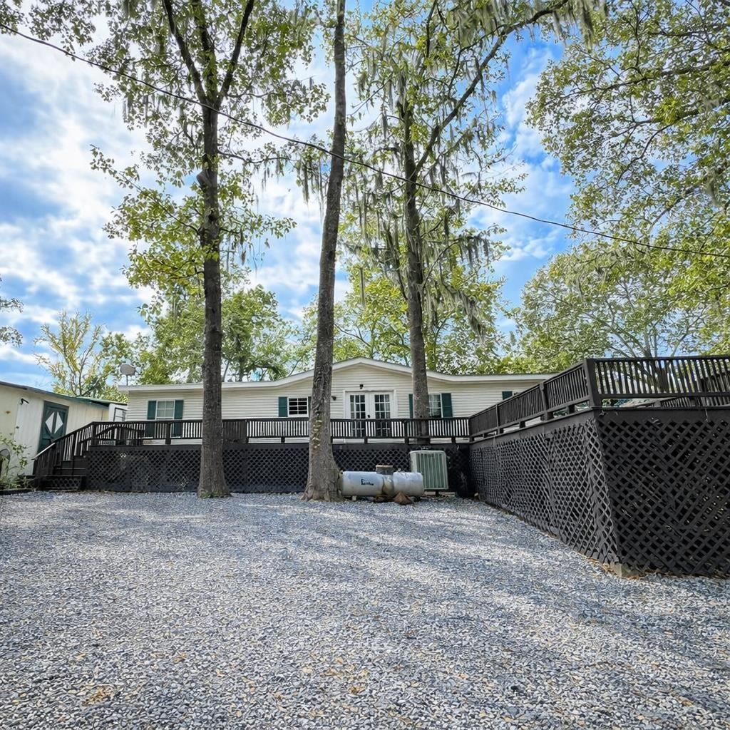 Image 1: Rear view of property featuring a wooden deck, Back Of Structure