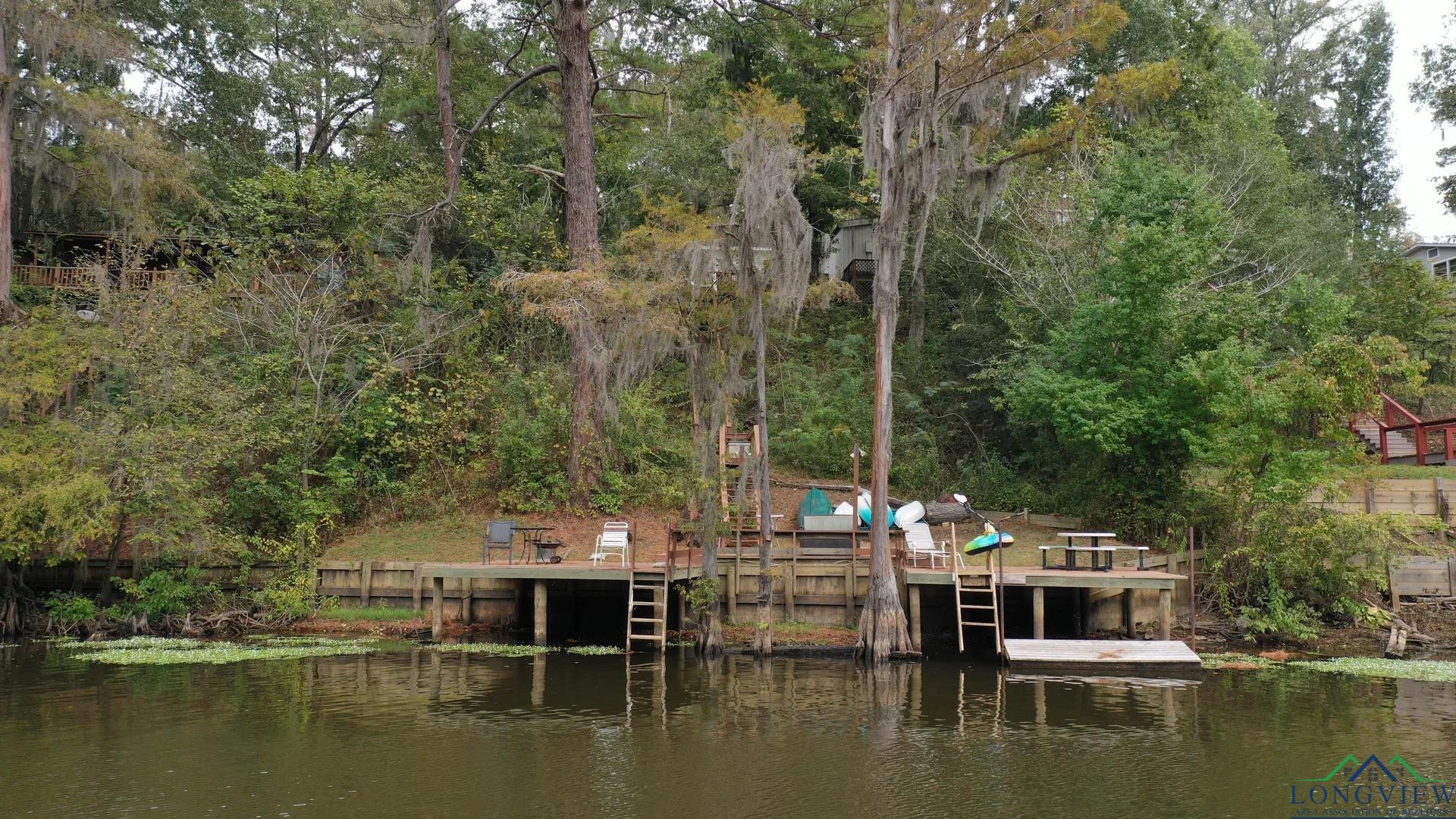 Image 2: Dock area featuring a water view and a view of trees, Dock