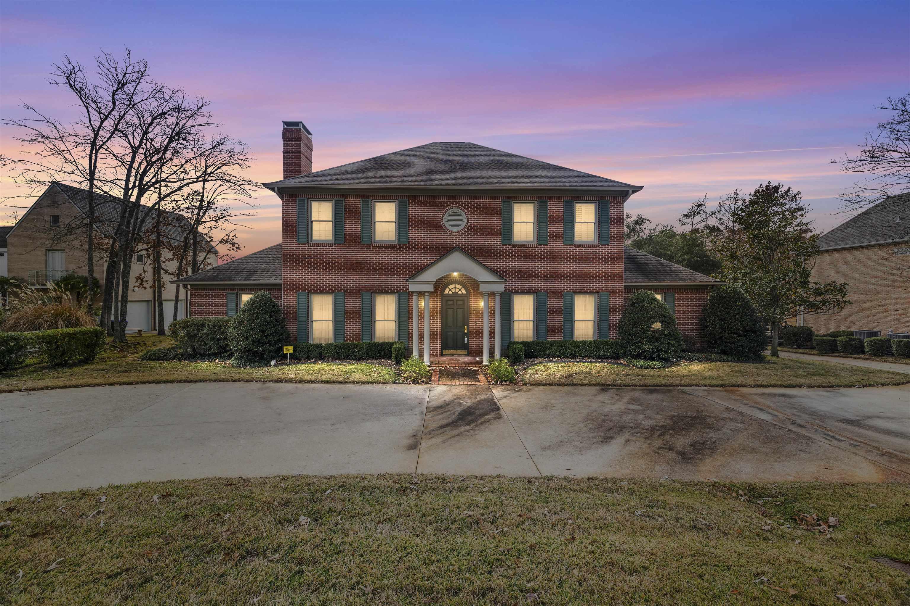 Image 0: View of front facade with a chimney, brick siding, a front yard, and driveway, Front Of Structure