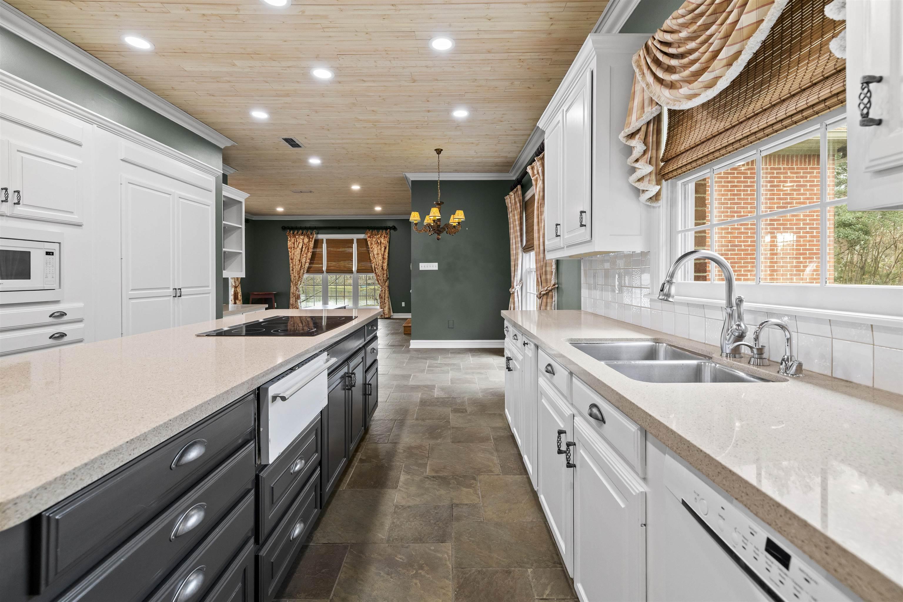 Image 1: Kitchen featuring white cabinets, light stone countertops, hanging light fixtures, recessed lighting, and wood ceiling, Kitchen