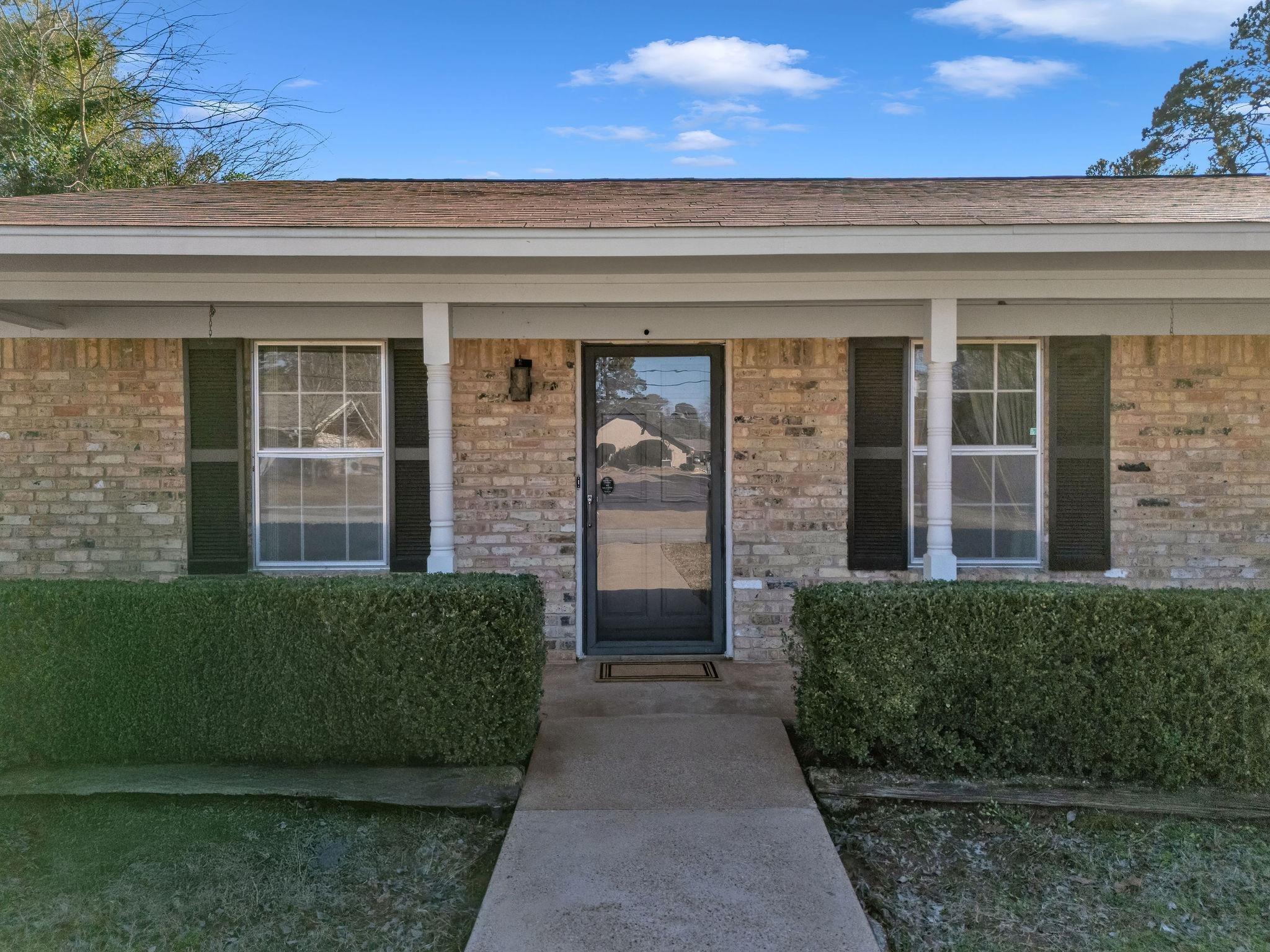 Image 1: View of exterior entry featuring a porch and brick siding, Entry