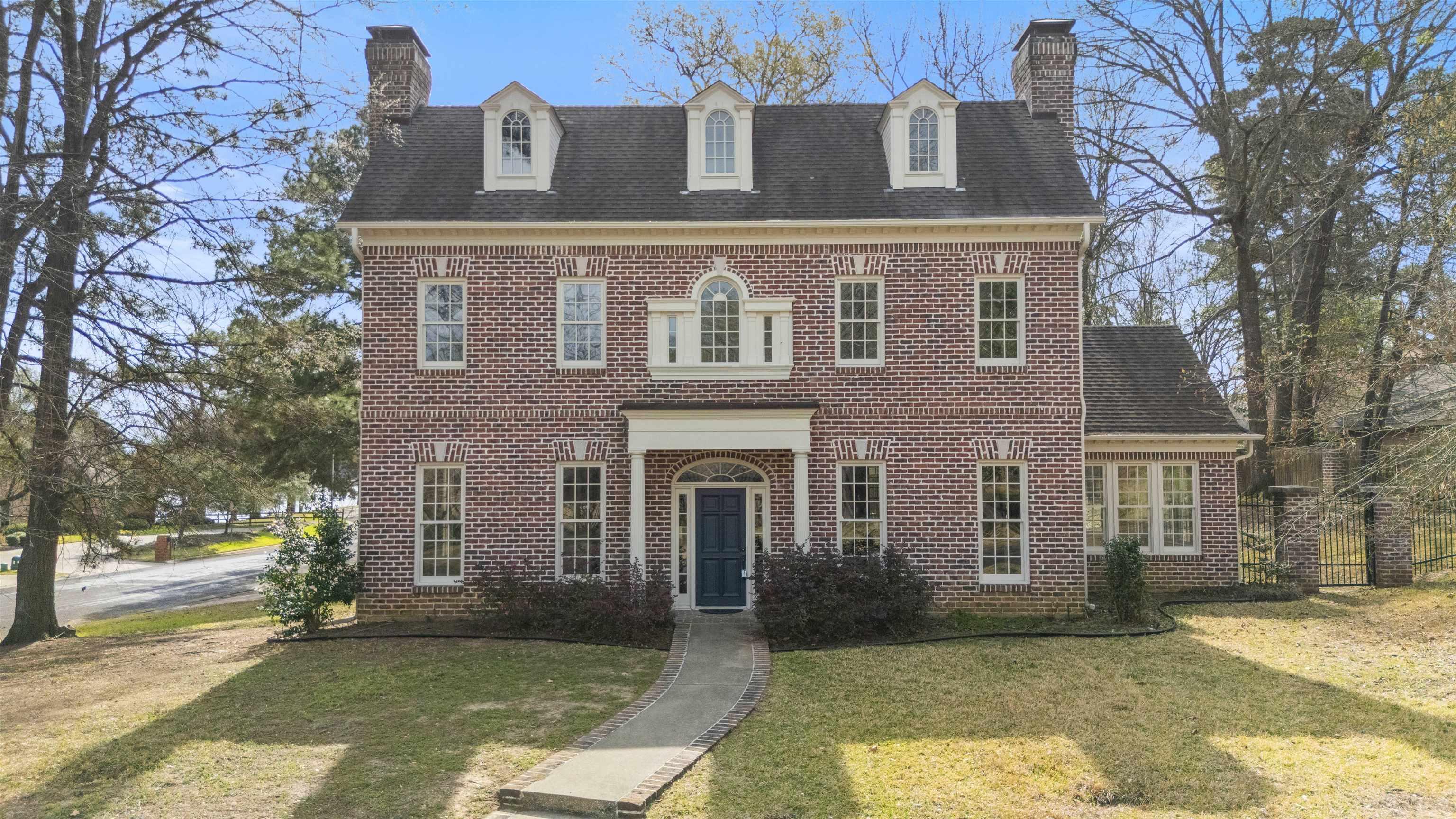 Image 0: Georgian-style home featuring a chimney, brick siding, a front lawn, and roof with shingles, Front Of Structure