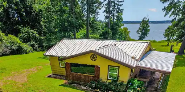 Image 1: Ranch-style dwelling with a metal roof and a covered porch, Front Of Structure
