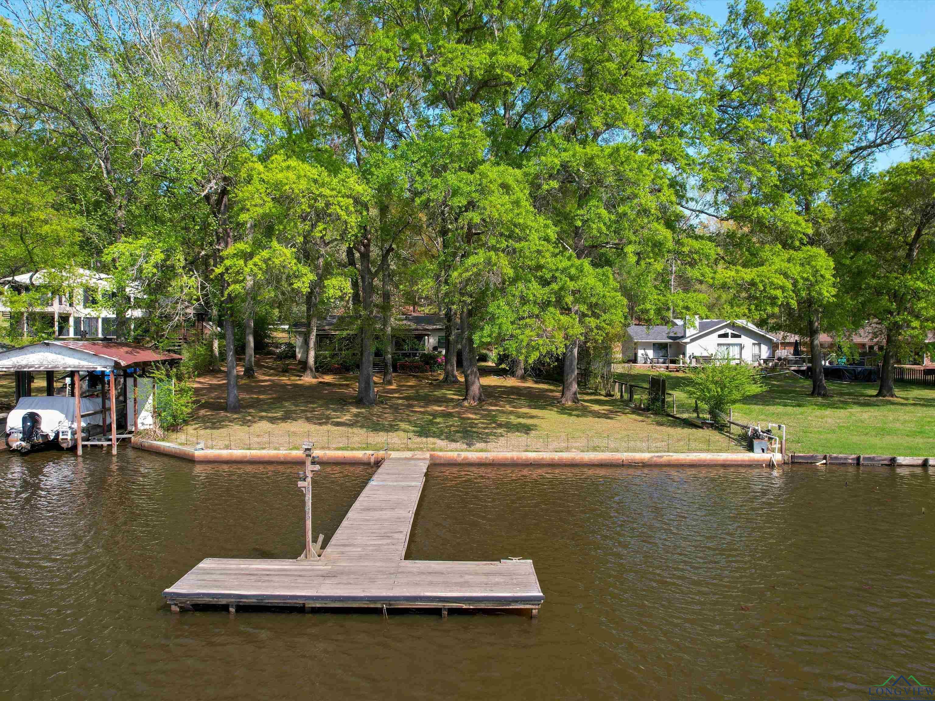 Image 0: Dock area with a water view and view of wooded area, Dock