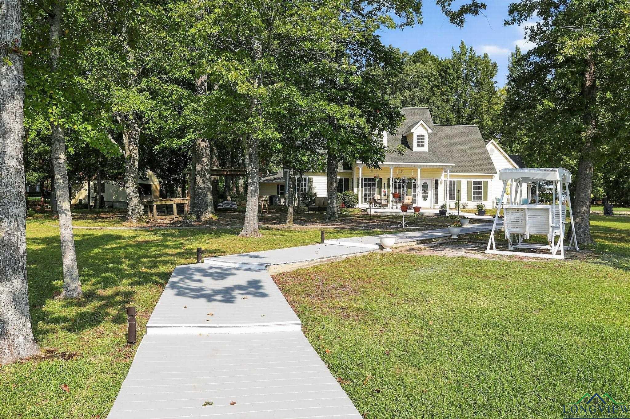 Image 2: View of front facade with a front yard, a porch, and view of scattered trees, Front Of Structure