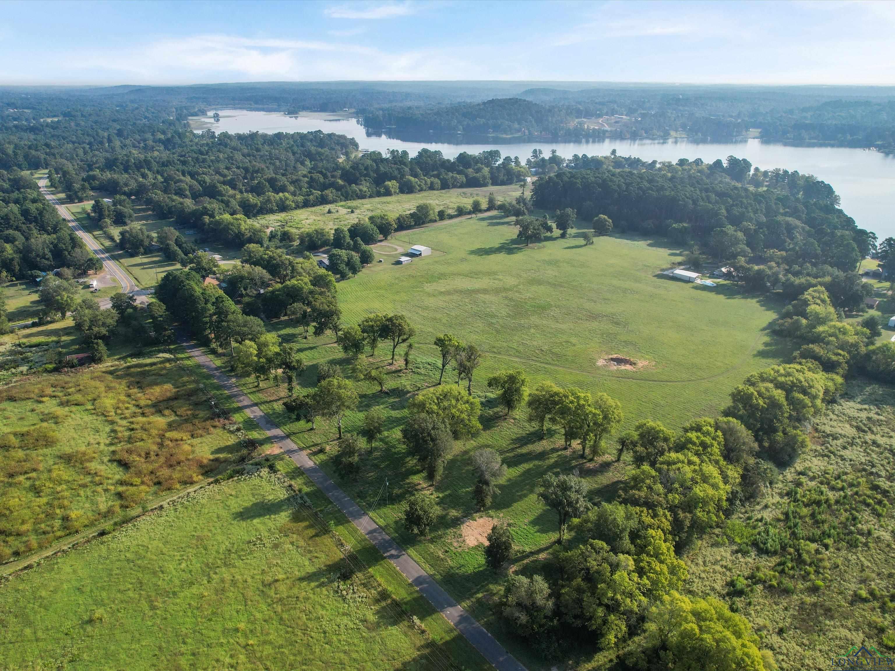 Image 2: View of property location with a large body of water and a forest, Aerial View