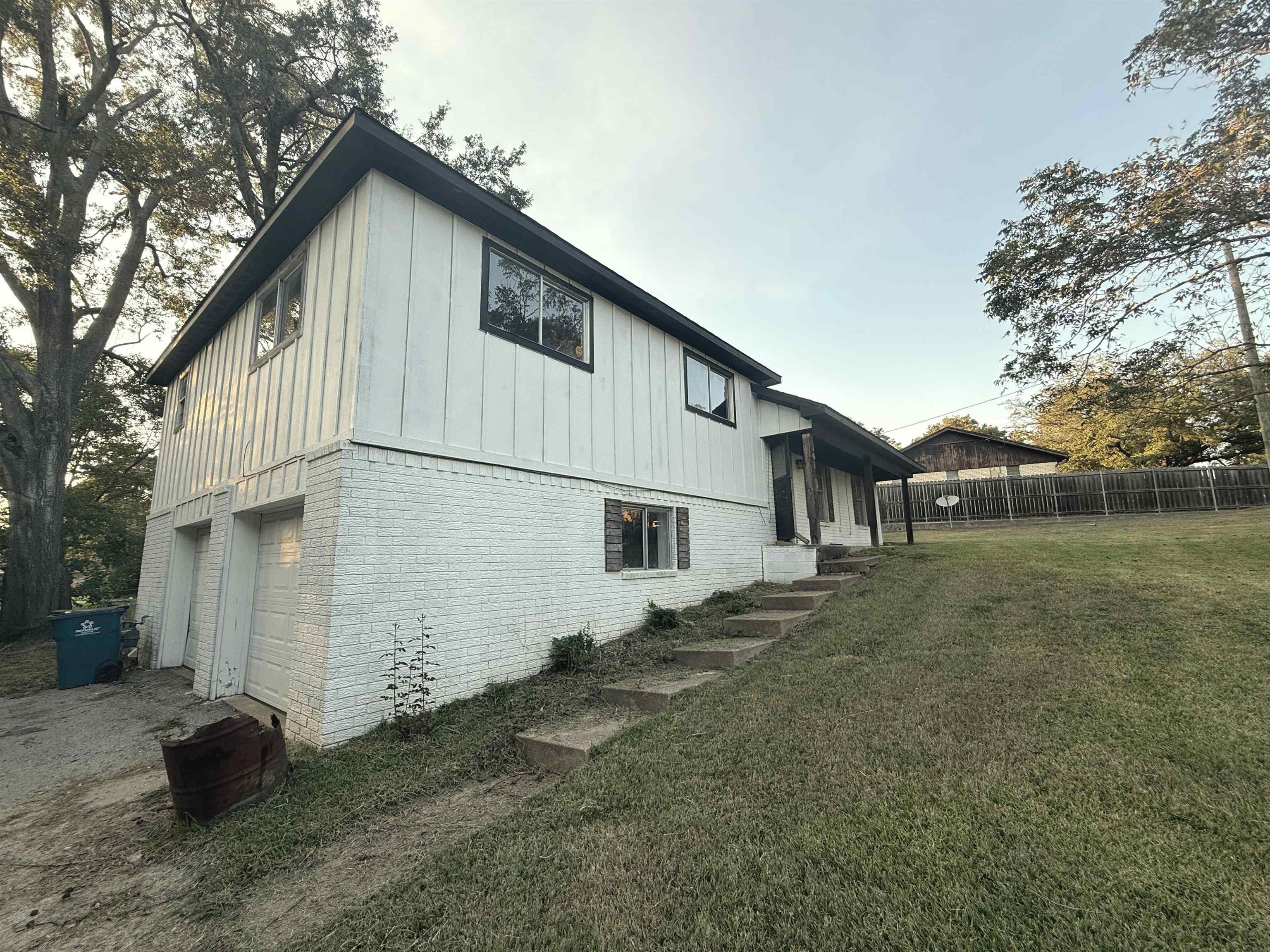 Image 0: Rear view of house featuring brick siding, board and batten siding, and an attached garage, Back Of Structure