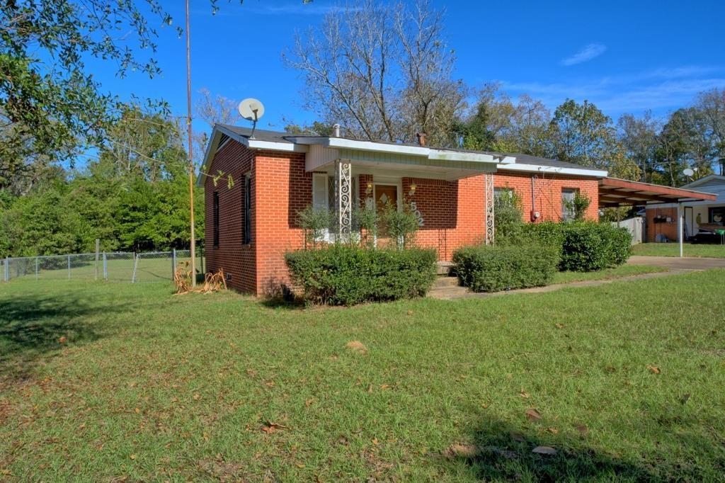 Image 1: View of property exterior with a porch, brick siding, and an attached carport, Side Of Structure