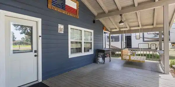 Image 2: Covered porch with wood-finish decking, plank siding, multi-pane windows, and a ceiling fan, Deck