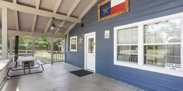 Image 3: Expansive covered porch with a sloped ceiling and exposed beams, Deck