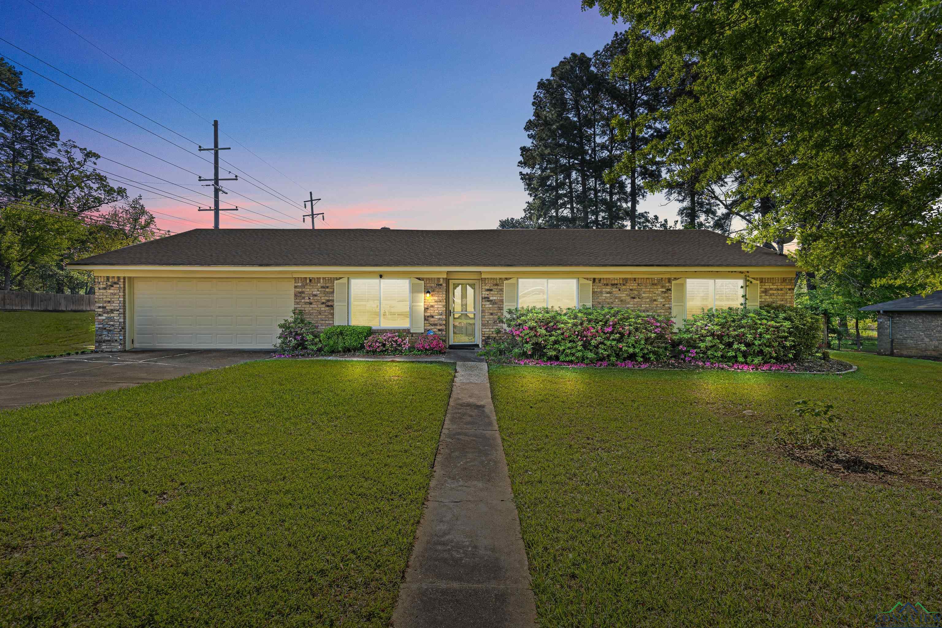 Image 0: View of front of property featuring a lawn, a garage, concrete driveway, brick siding, and roof with shingles, Front Of Structure