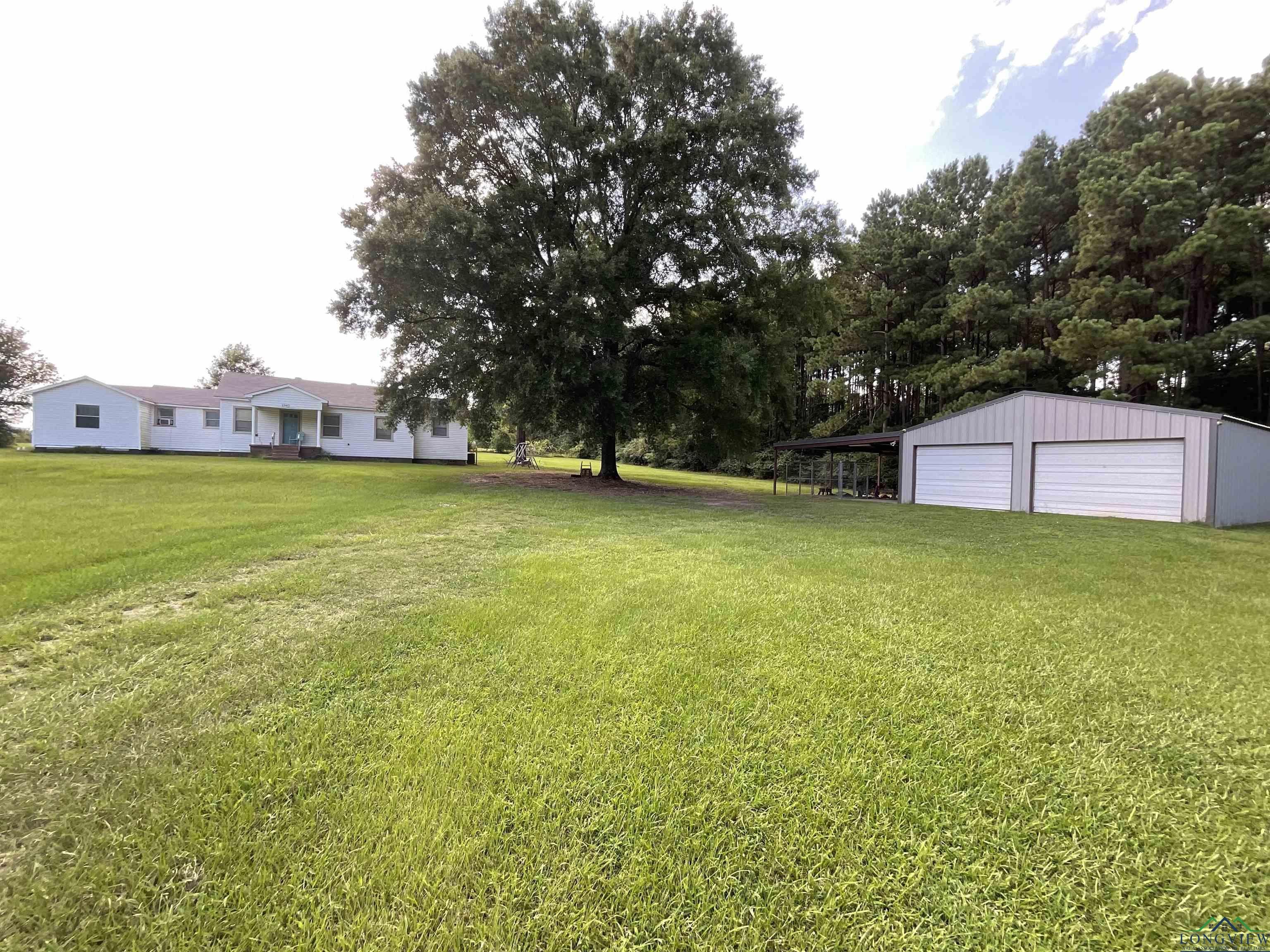 Image 0: View of green lawn with a garage and an outbuilding, Yard