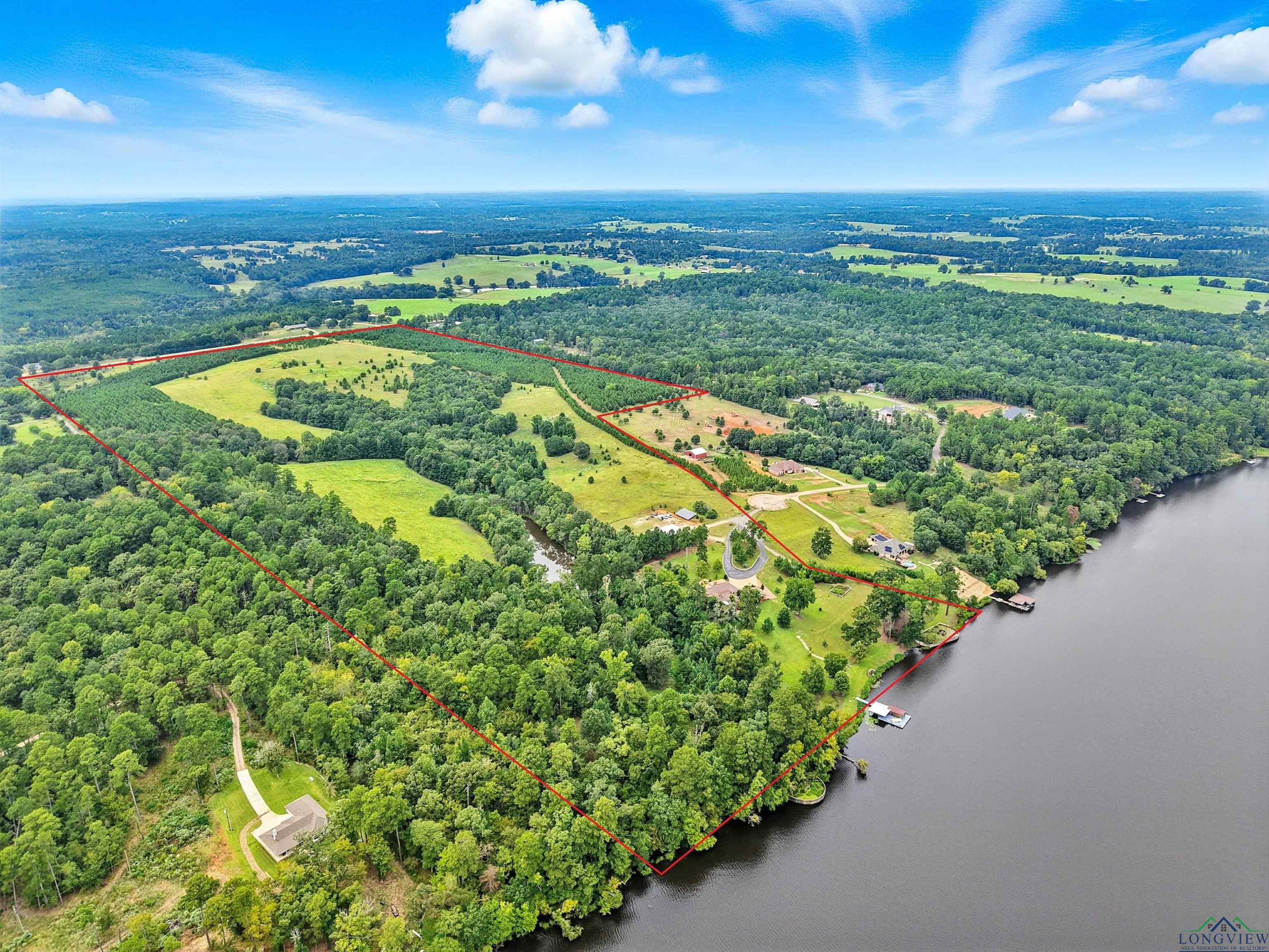 Image 1: Property is gated and fenced. Includes the main house, a guest house, boat house, barn with tractor shed., Aerial View