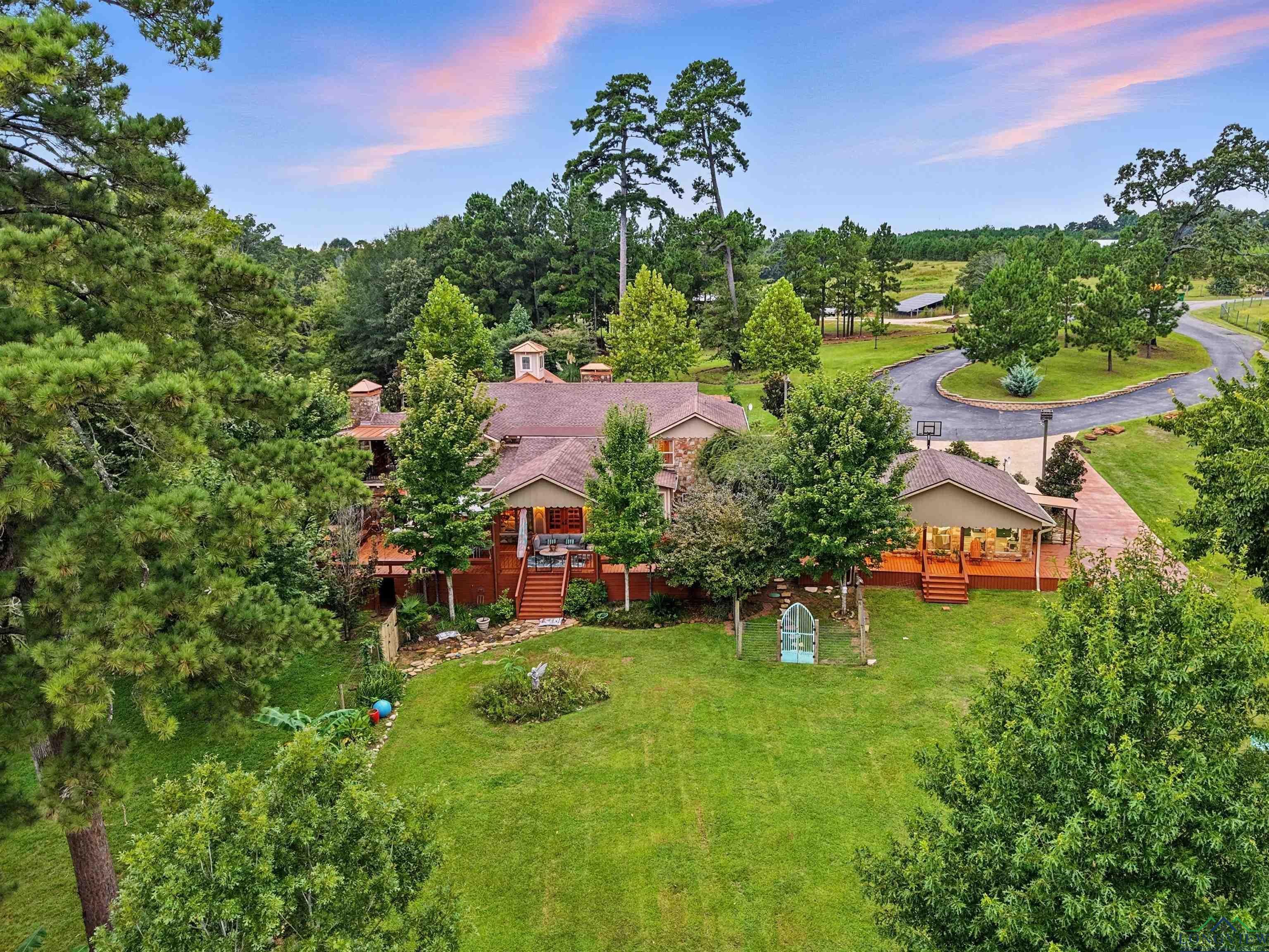 Image 3: Circular driveway leads down to the Main house and Guest house overlooking the lake., Aerial View