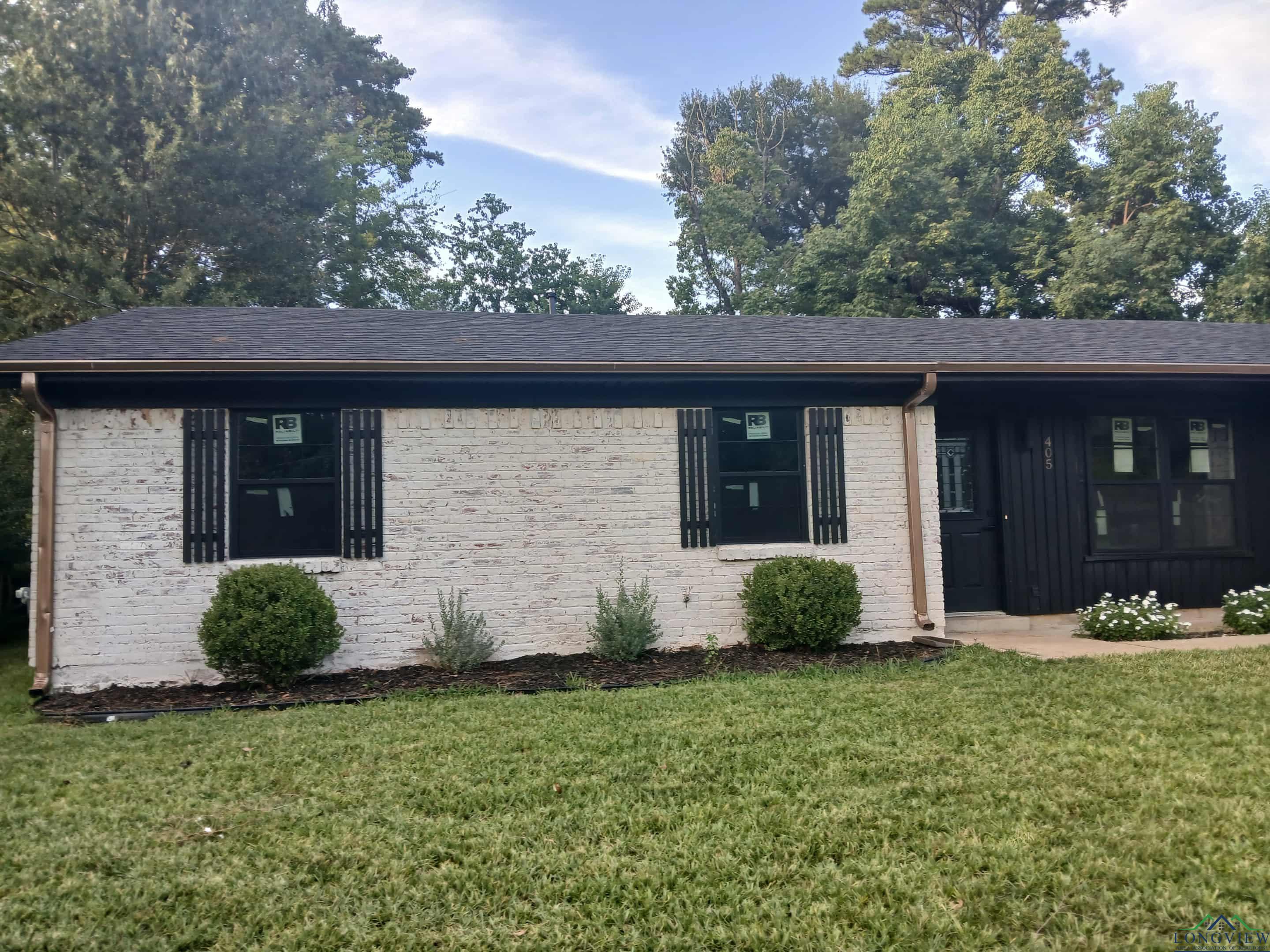 Image 1: Single story home featuring a front yard, brick siding, and covered porch, Front Of Structure