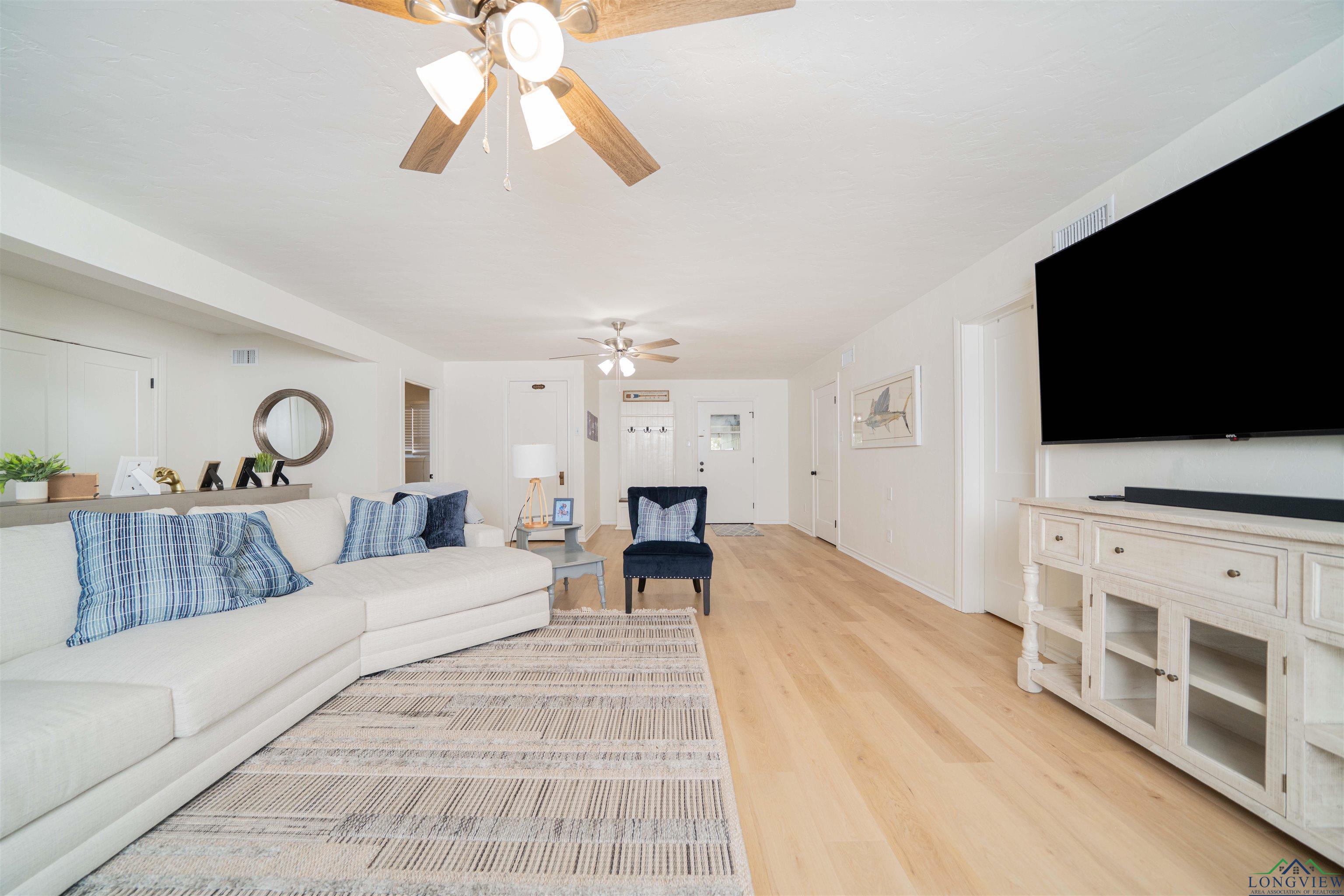Image 3: Living room with light wood-style flooring and ceiling fan, Living Room