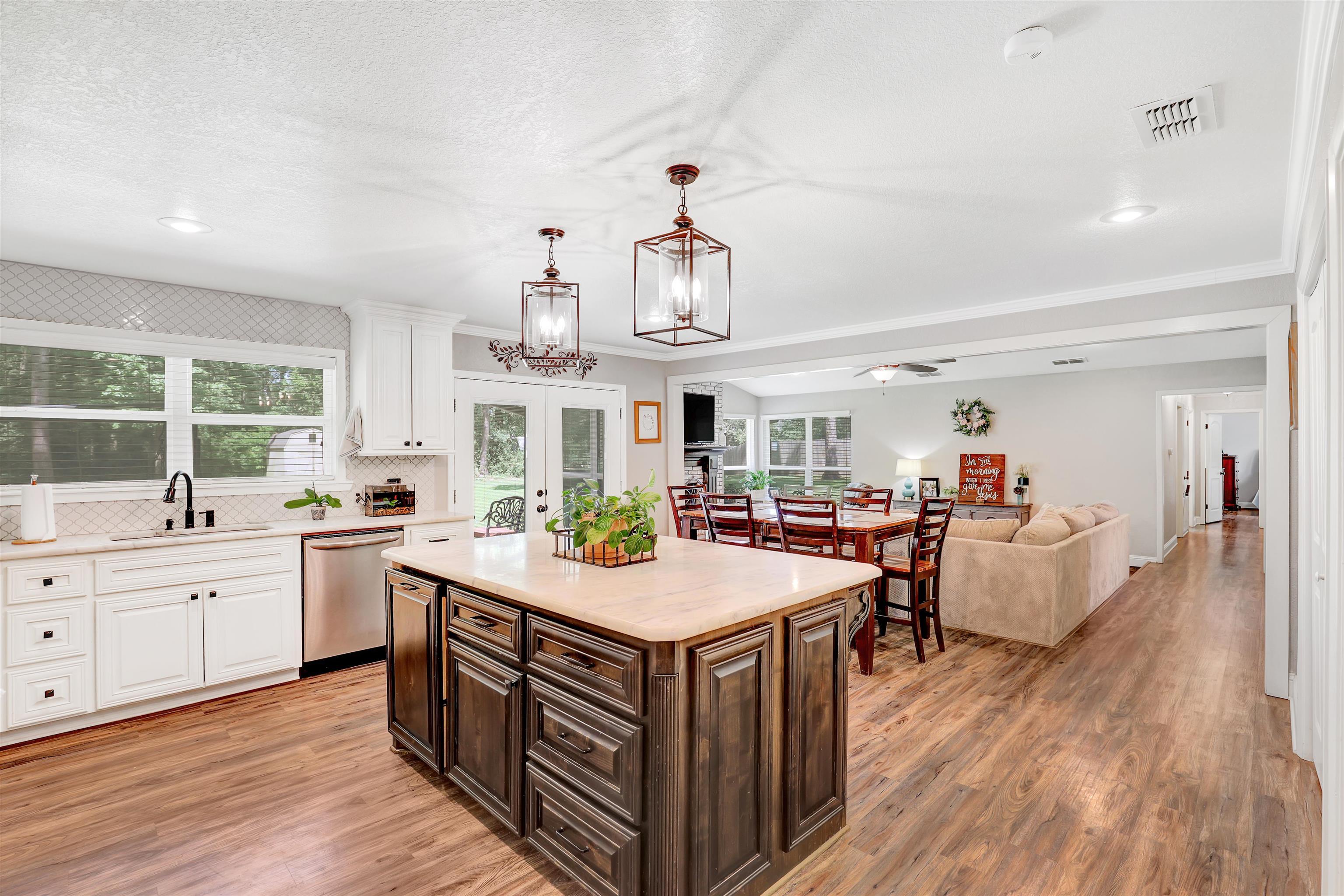 Image 3: Kitchen featuring an expansive center island with dark wood cabinetry and a light-toned countertop, Kitchen