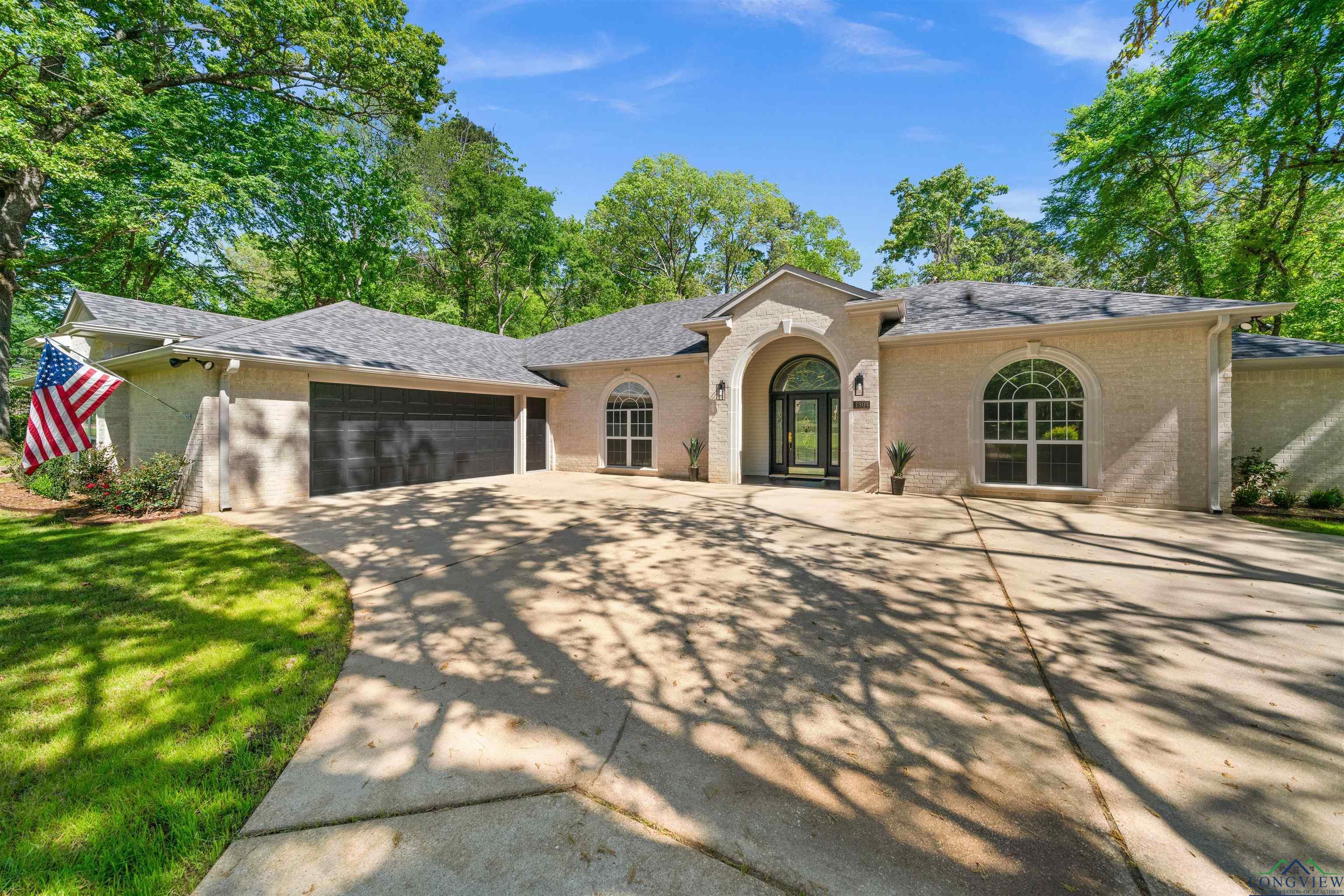 Image 0: Mediterranean / spanish-style house with brick siding, a garage, a shingled roof, driveway, and a front lawn, Front Of Structure