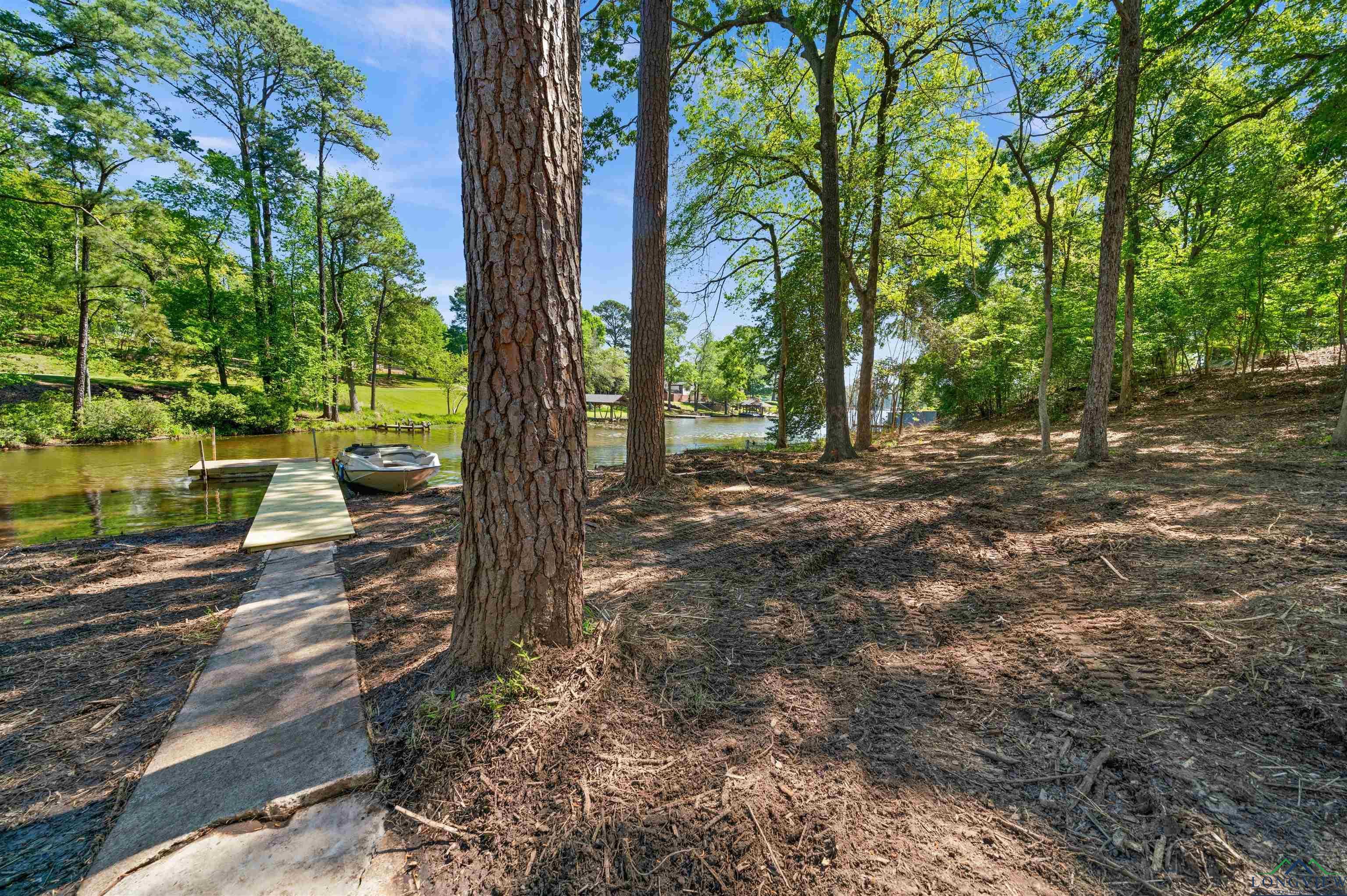 Image 2: View of yard featuring a dock and a water view, Yard
