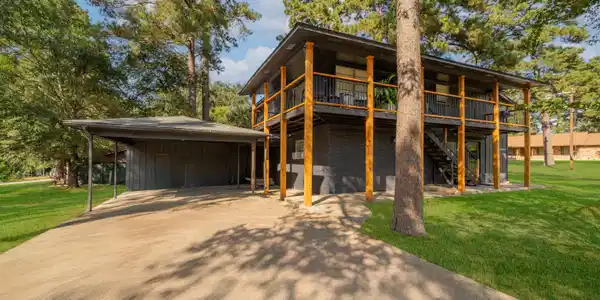 Image 1: View of front facade featuring a front lawn, a carport, driveway, and stairs, Front Of Structure