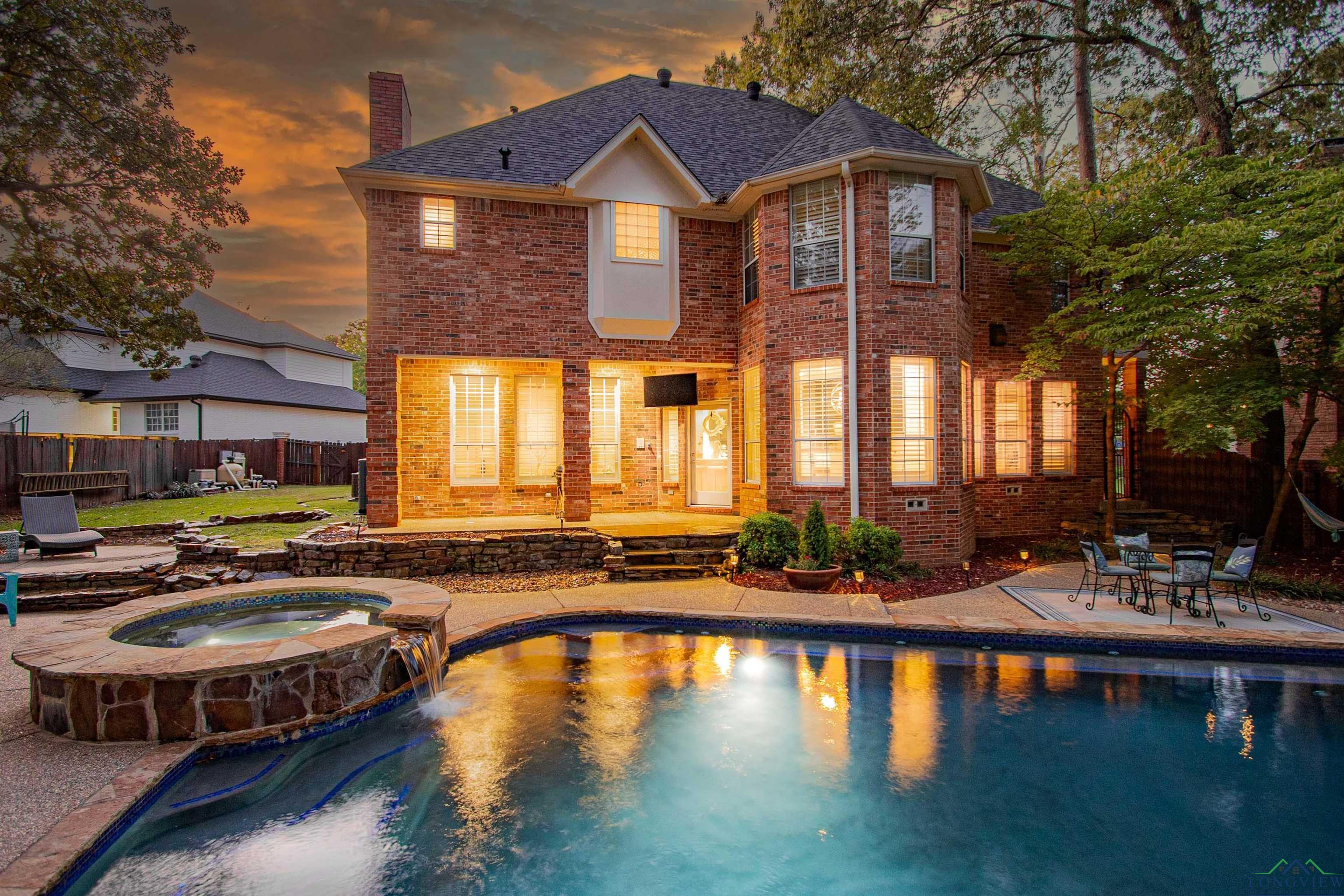 Image 1: View of swimming pool with a patio area and a pool with connected hot tub, Pool