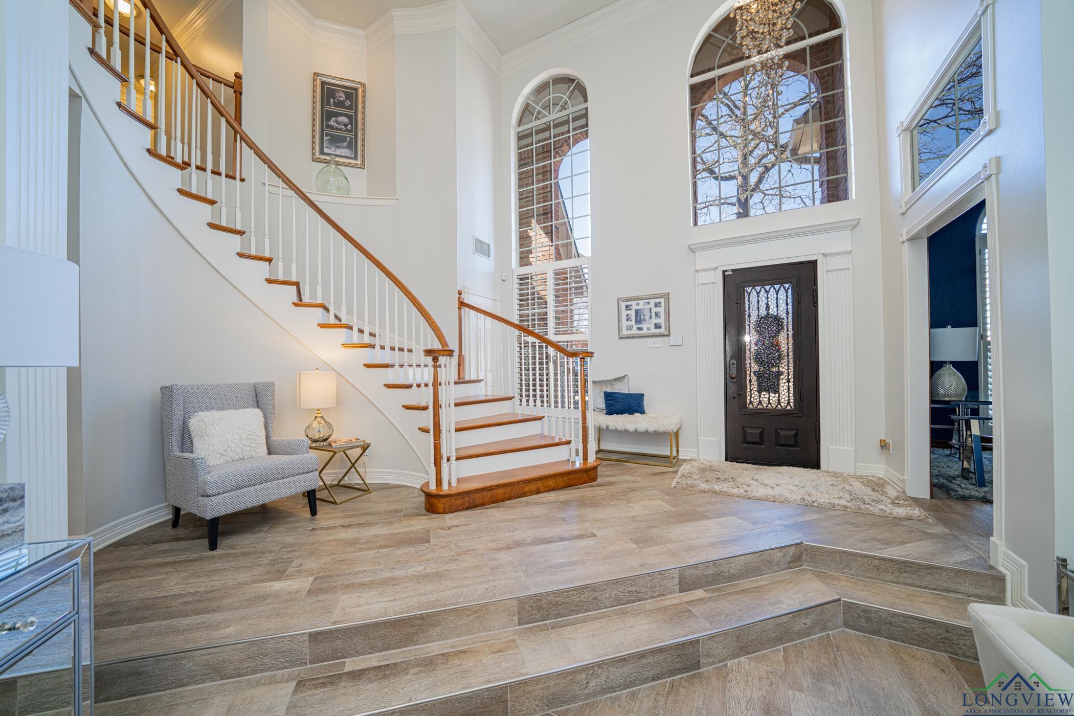 Image 2: Foyer entrance with a towering ceiling, wood finished floors, stairway, and ornamental molding, Entrance Foyer