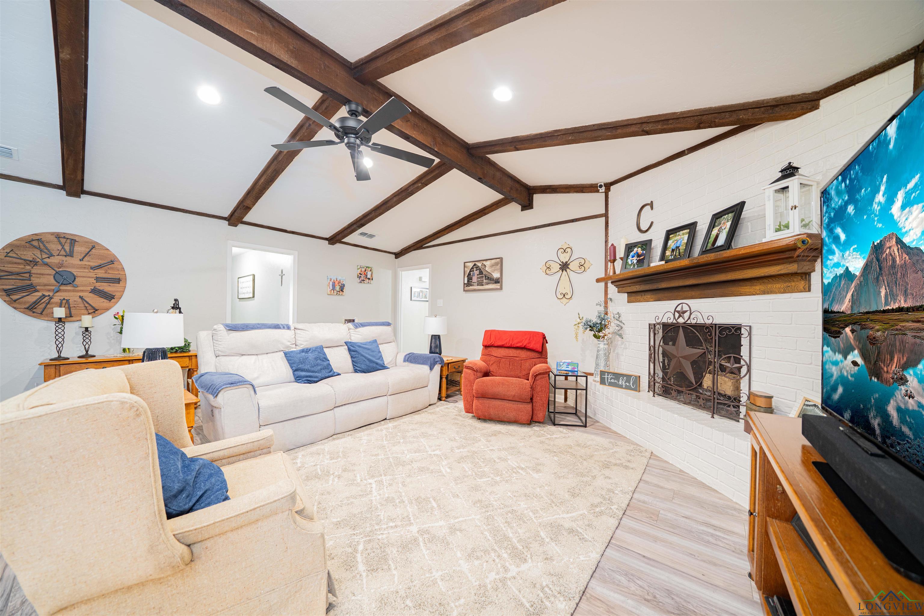 Image 2: Living room featuring wood finished floors, ceiling fan, and a fireplace, Living Room