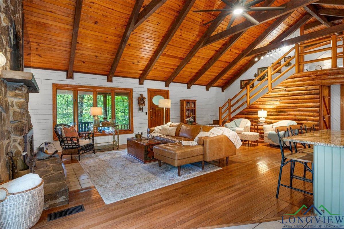 Image 1: Living area featuring stairway, high vaulted ceiling, light wood finished floors, and a wood ceiling with exposed beams, Living Room