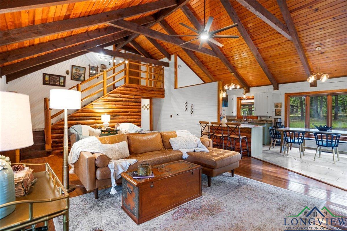 Image 3: Living room featuring wood-type flooring, high vaulted ceiling, a wood ceiling with exposed beams, a chandelier, and ceiling fan, Living Room
